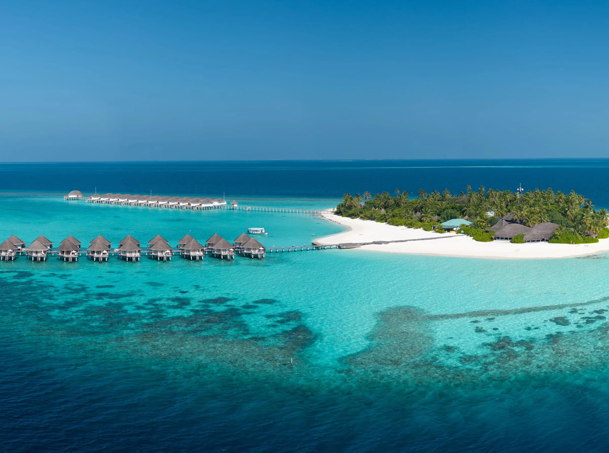 Spiaggia con sabbia bianca e bungalow sull'acqua al Angaga Island Resort & Spa.