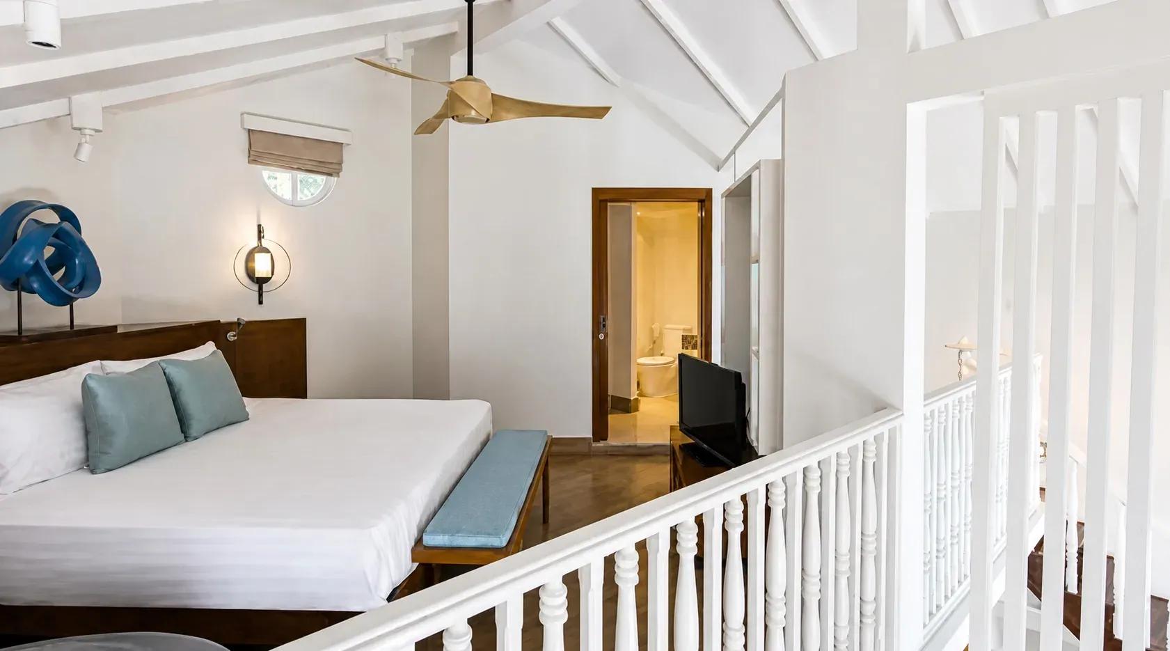 Camera da letto della Club Two Bedroom Beach Pool Villa con letto matrimoniale e ventilatore a soffitto al Centara Machchafushi Island Resort & Spa Maldives