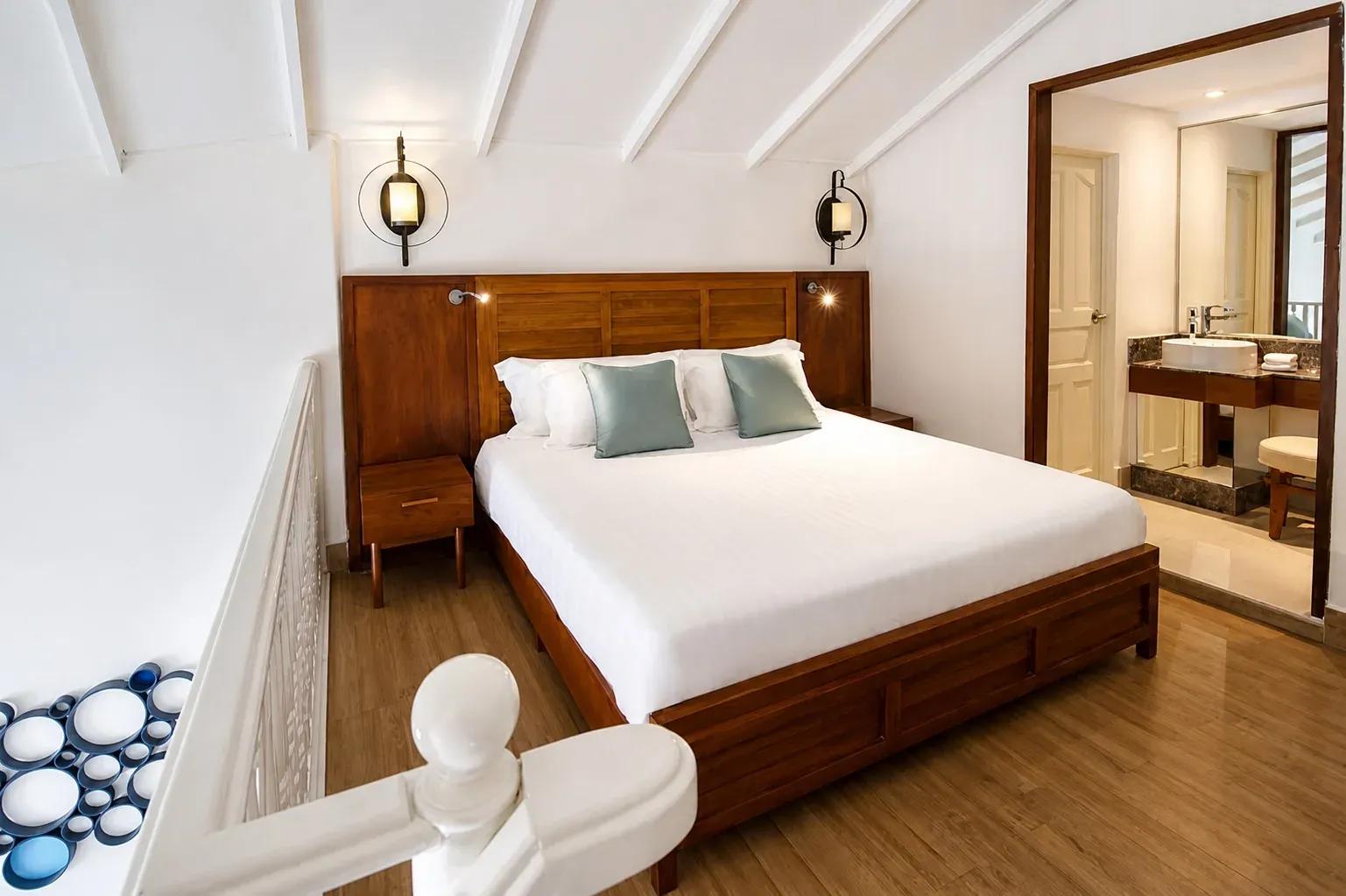 Camera della Duplex Beach Villa con letto matrimoniale e bagno annesso al Centara Machchafushi Island Resort & Spa Maldives