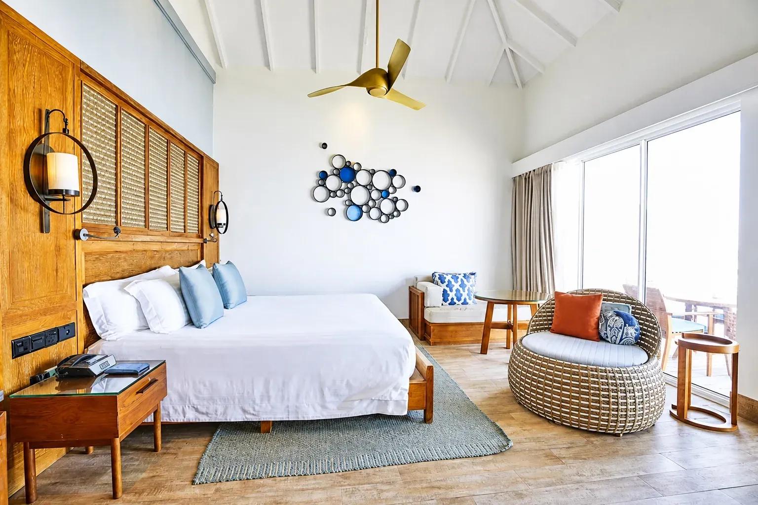 Interno della Family Overwater Villa with Kids Bedroom con letto matrimoniale e area relax presso Centara Machchafushi Island Resort & Spa Maldives.