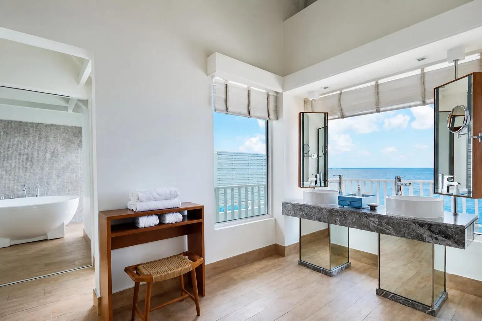 Bagno della Family Overwater Villa with Kids Bedroom con vasca e doppio lavabo al Centara Machchafushi Island Resort & Spa Maldives.