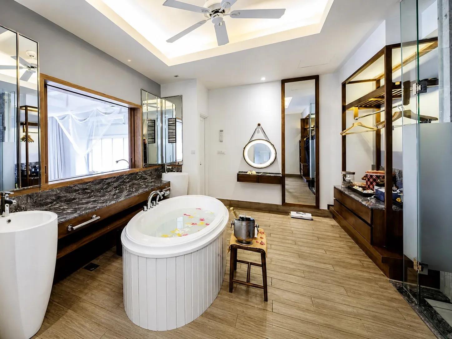 Bagno della Reethi Muraka Overwater Villa con vasca freestanding e lavabo al Centara Machchafushi Island Resort & Spa Maldives.