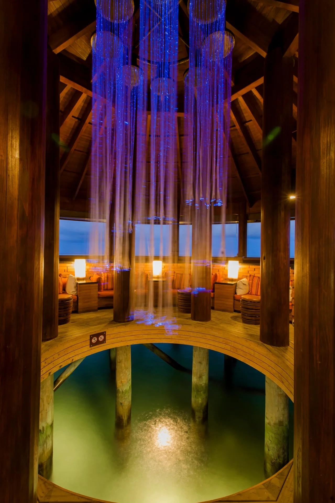 Interno con soffitto in legno e luci blu al Centara Ras Fushi Resort & Spa Maldives
