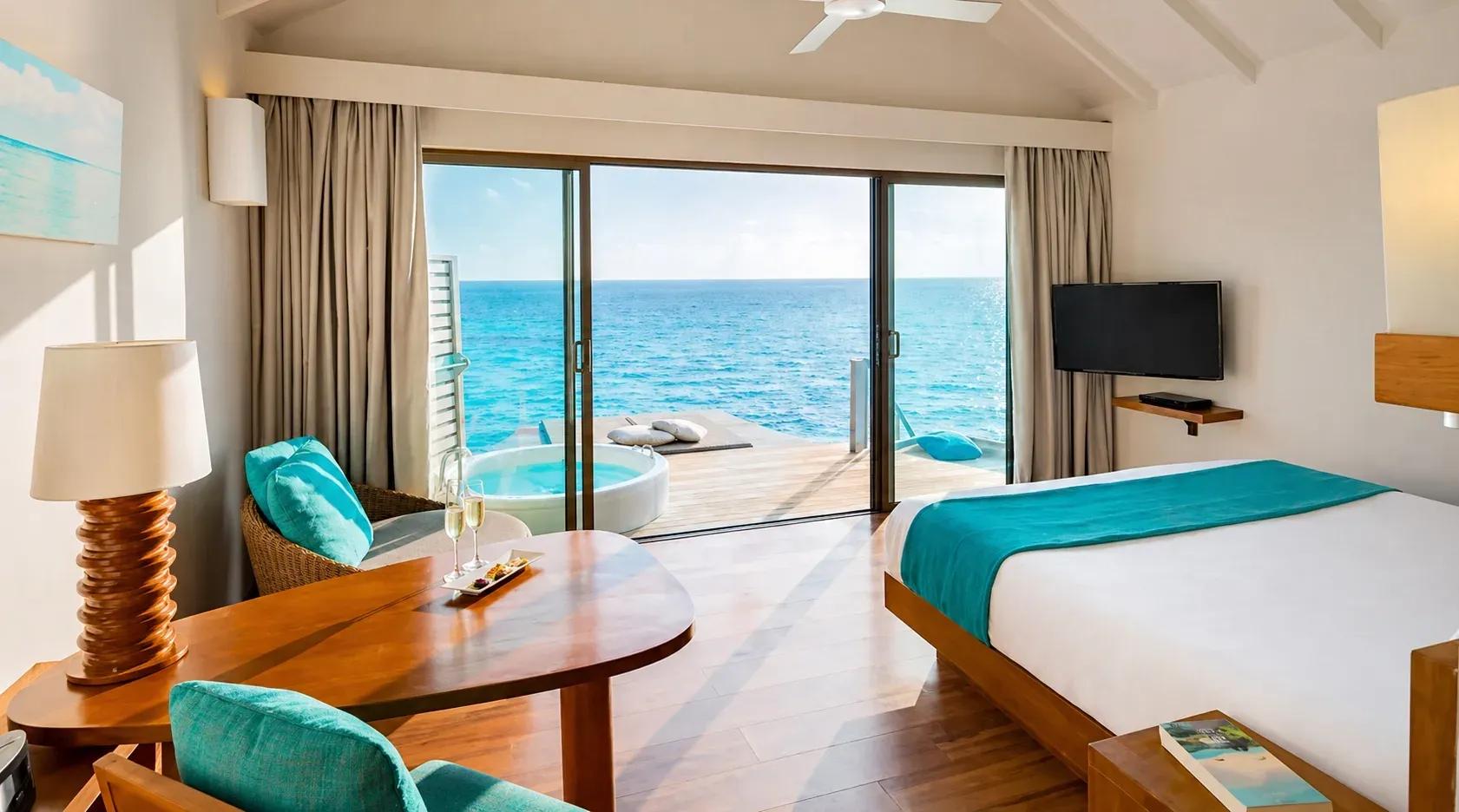Interno della Overwater Villa with Swirl Pool con letto matrimoniale e vista sull'oceano al Centara Ras Fushi Resort & Spa Maldives.