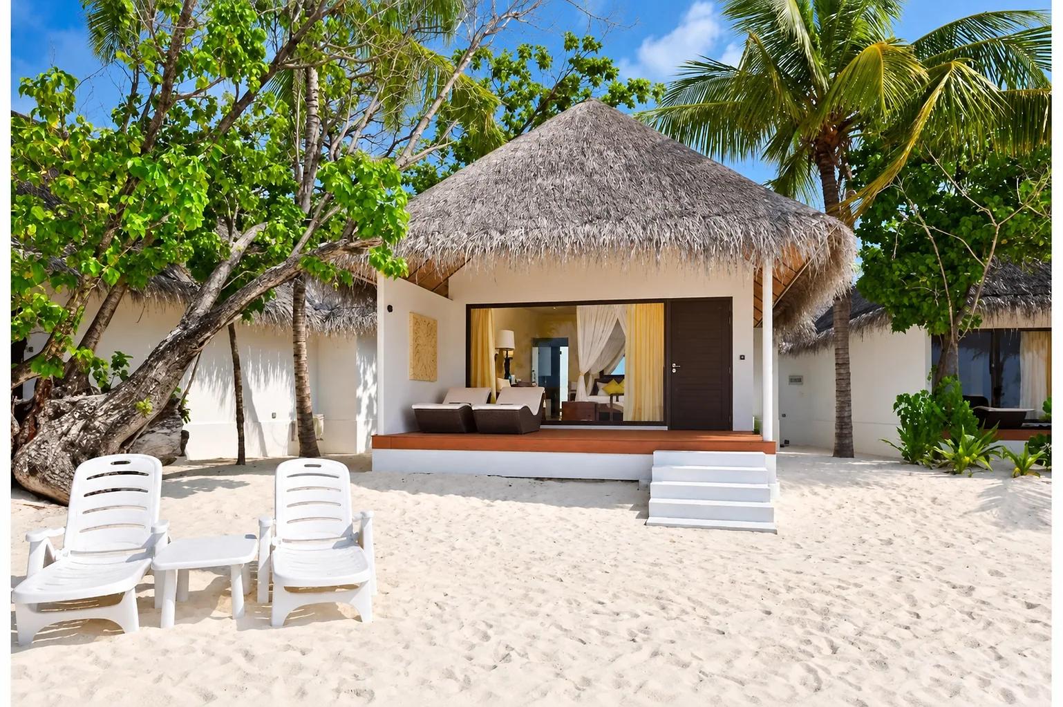 Un Beach Bungalow del Dreamland The Unique Sea And Lake Resort Spa sulla sabbia bianca, con tetto di paglia, veranda e lettini prendisole tra la vegetazione tropicale.