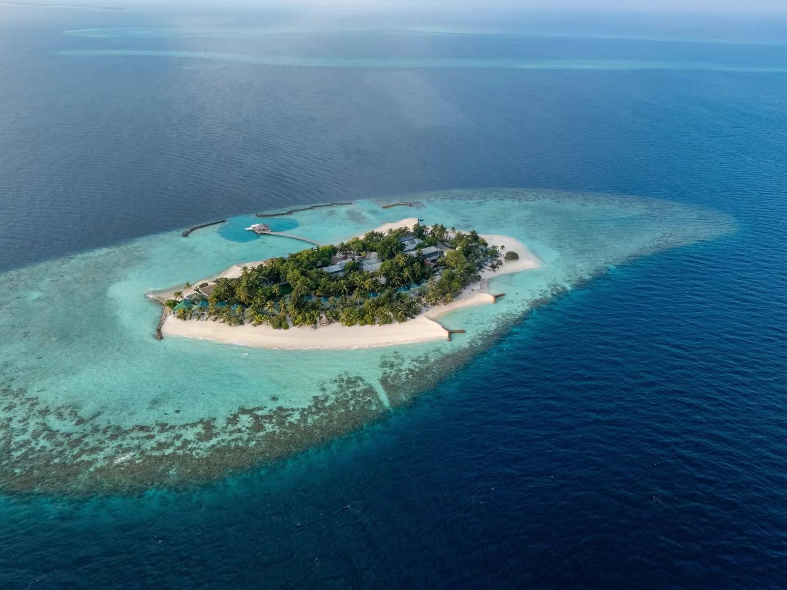 Vista aerea dell'isola di Eri Maldives, circondata da spiagge di sabbia bianca, vegetazione tropicale, laguna turchese e barriera corallina