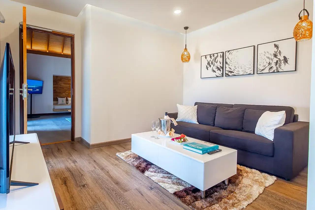 Soggiorno della Beach Duplex Villa con divano e tavolino al Fushifaru Maldives.