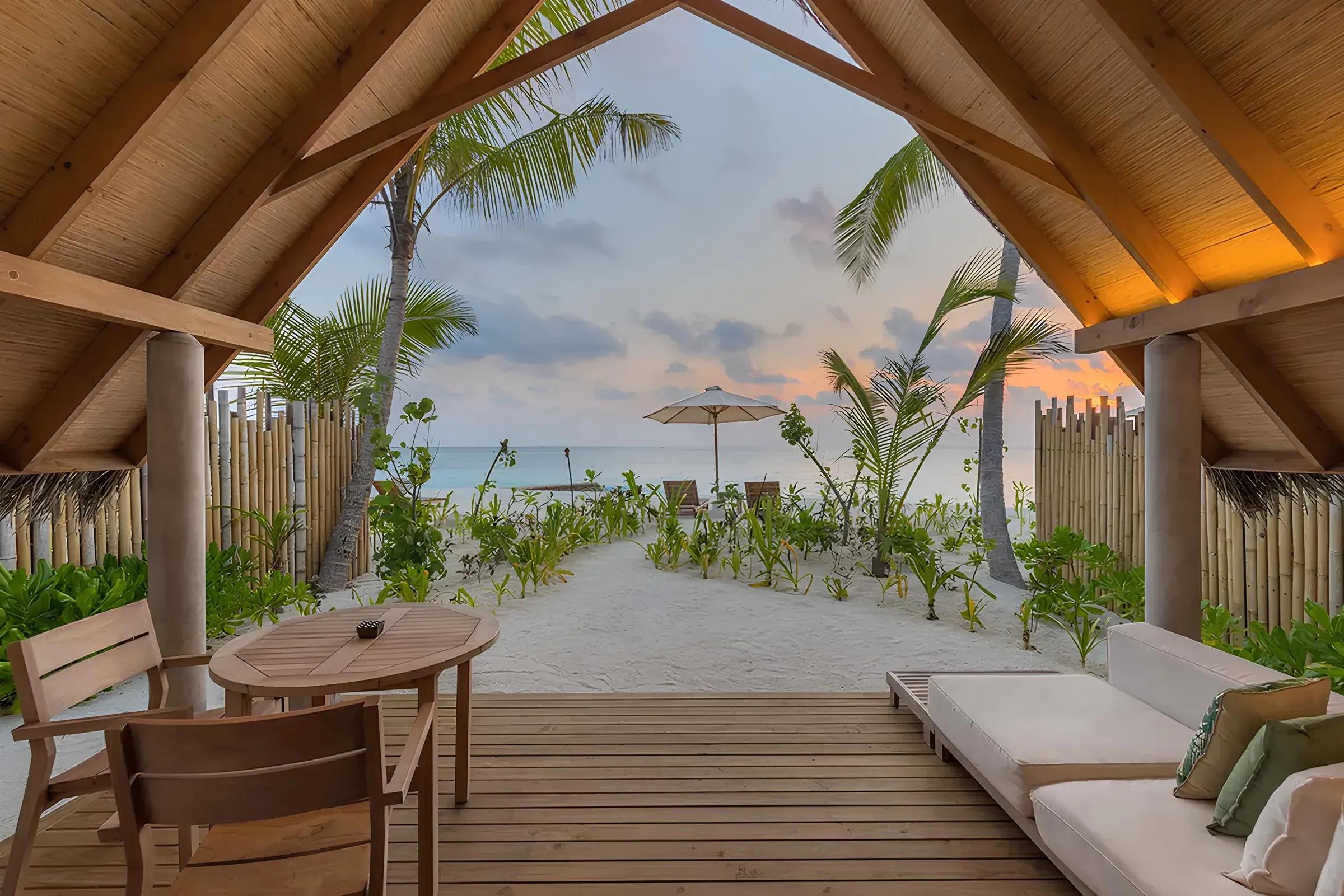 Vista dalla Beach Villa Sunrise con terrazza in legno e accesso diretto alla spiaggia del Fushifaru Maldives.