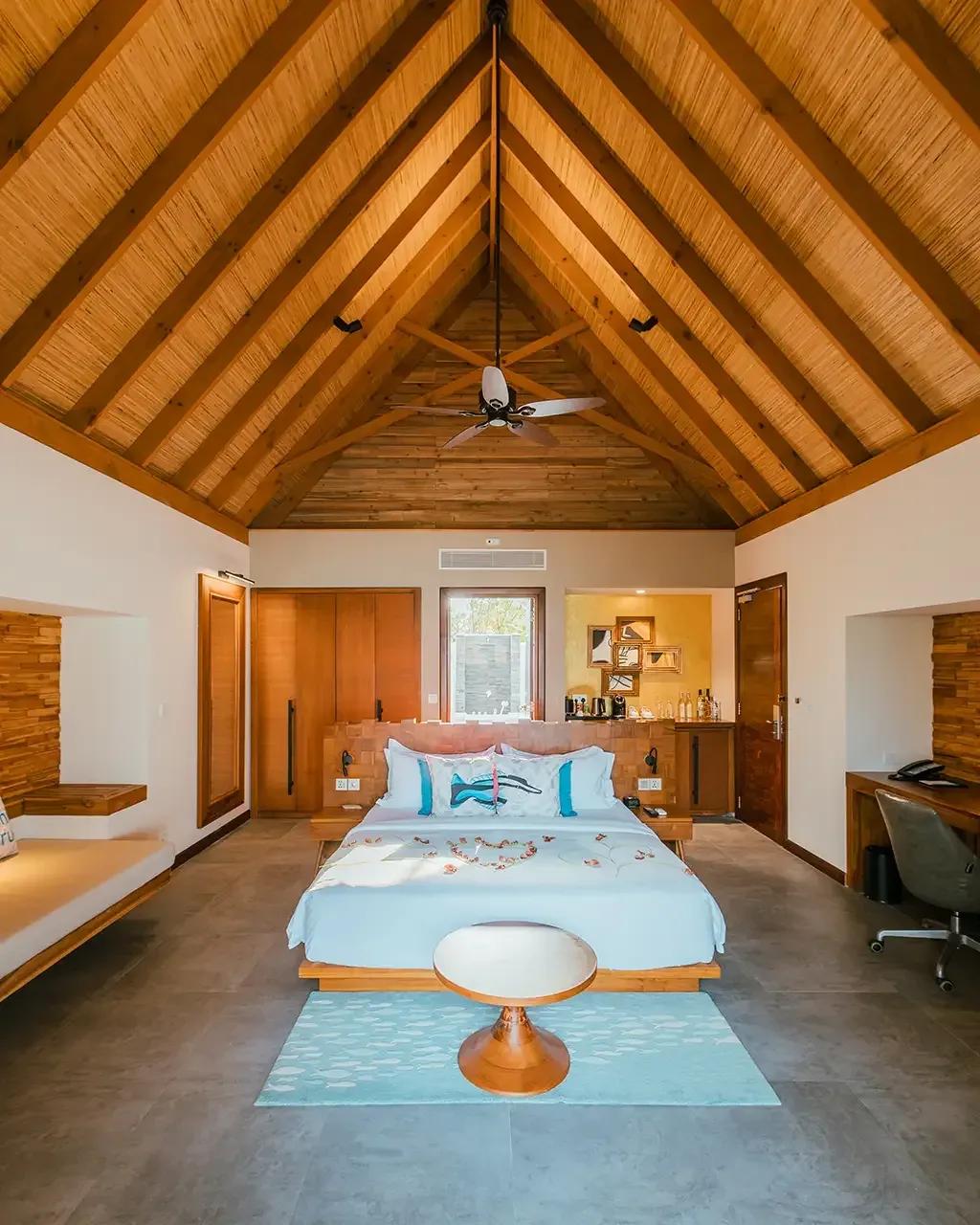 Camera da letto con soffitto in legno e ventilatore della Beach Villa Sunrise al Fushifaru Maldives