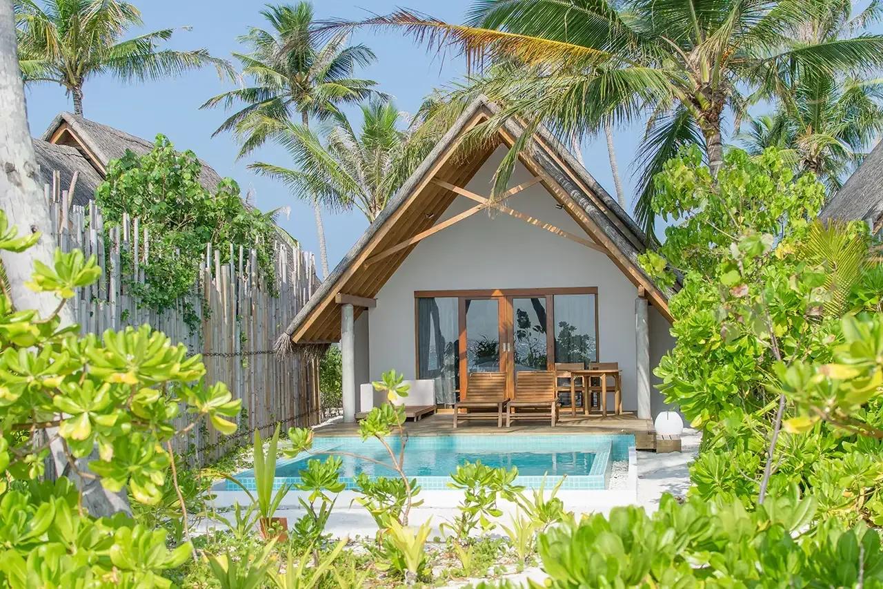 Pool Beach Villa Sunrise con piscina privata e terrazza in legno circondata da palme al Fushifaru Maldives