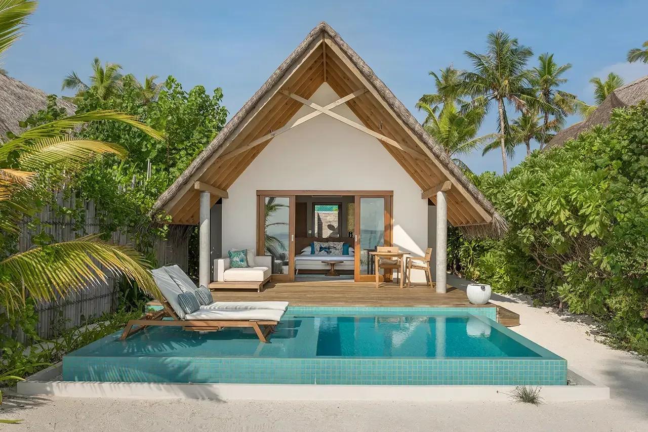 Pool Beach Villa Sunset con piscina privata e terrazza in legno al Fushifaru Maldives, circondata da palme tropicali.