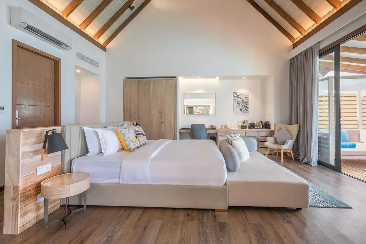 Camera da letto con letto matrimoniale e terrazza con piscina della Pool Water Villa al Fushifaru Maldives
