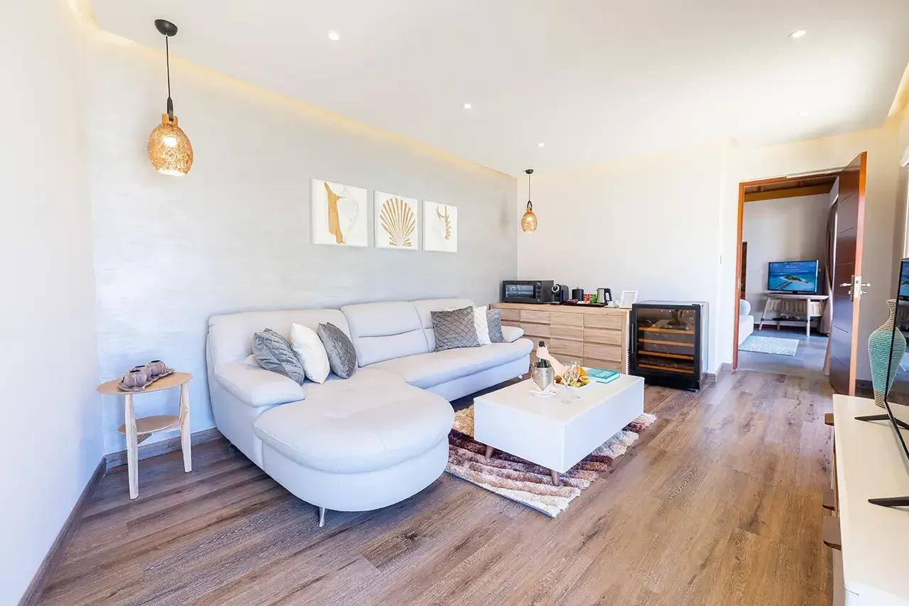 Soggiorno della Premium Beach Duplex Villa con divano bianco e tavolino al Fushifaru Maldives.