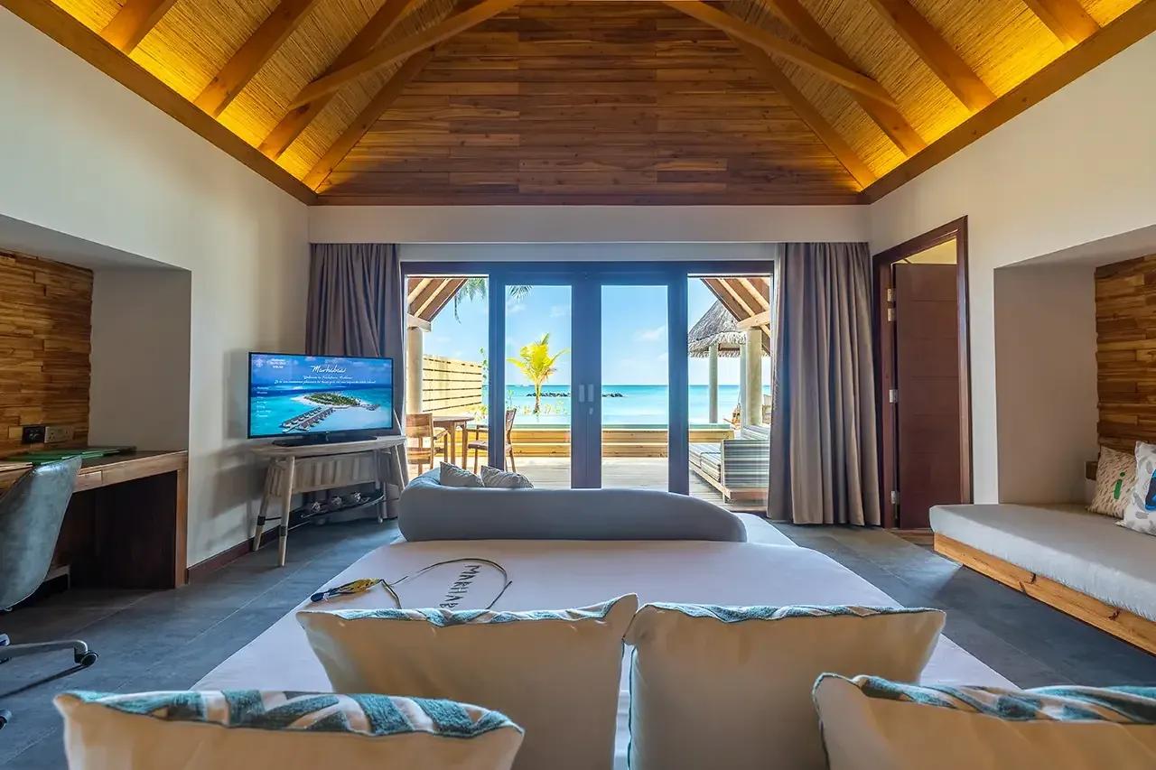 Camera con letto, soffitto in legno e vista mare dalla Premium Beach Duplex Villa del Fushifaru Maldives.