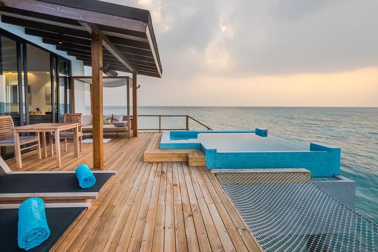 Terrazza in legno con piscina privata e vista mare della premium pool water villa al Fushifaru Maldives