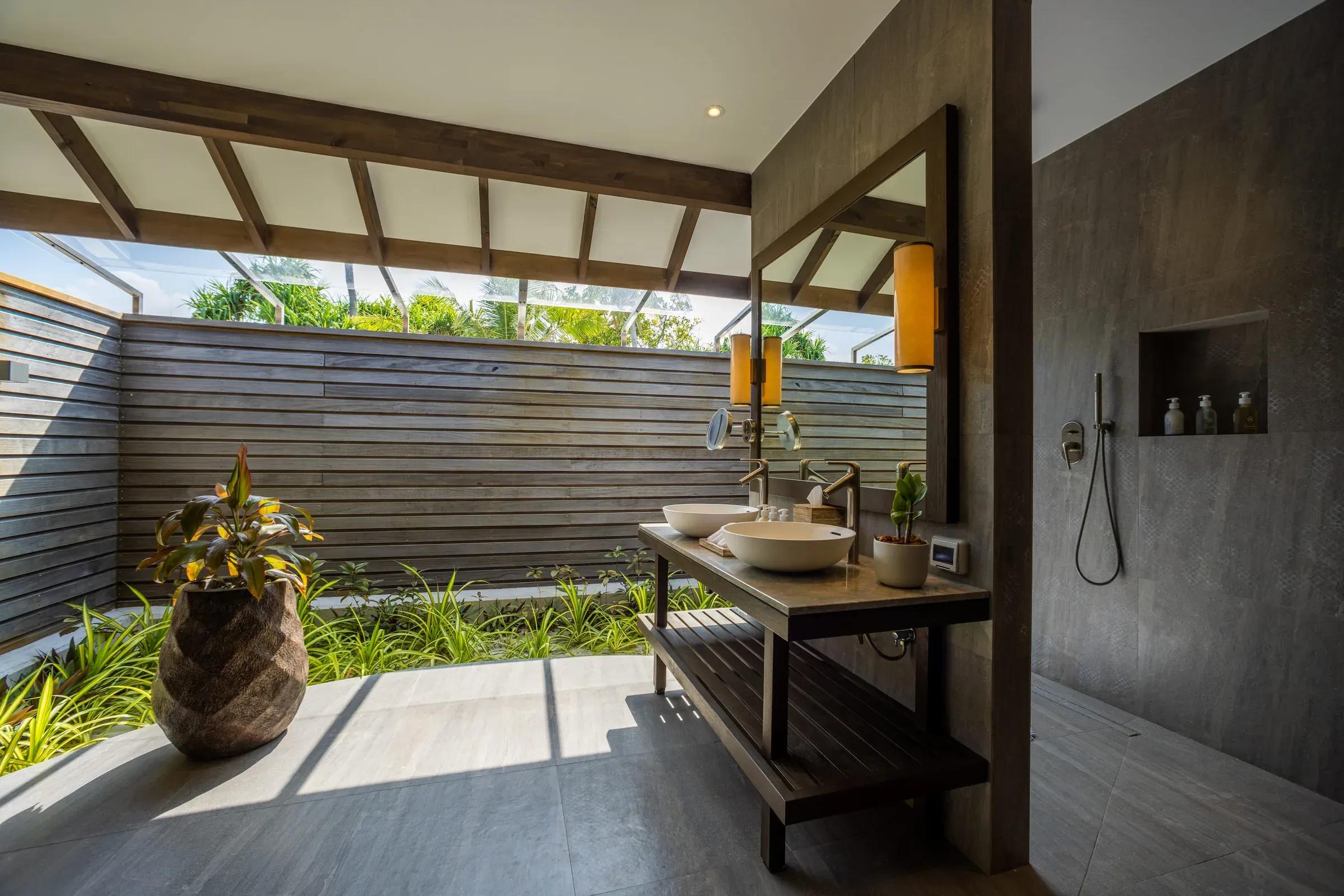 Bagno con lavabo doppio e doccia esterna nella Dheru Three Bedroom Villa, Jawakara Islands Maldives.