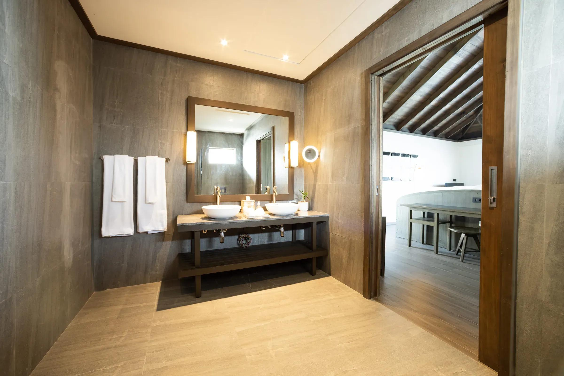 Bagno con doppio lavabo e specchio nella Dheru Water Pool Villa del Jawakara Islands Maldives