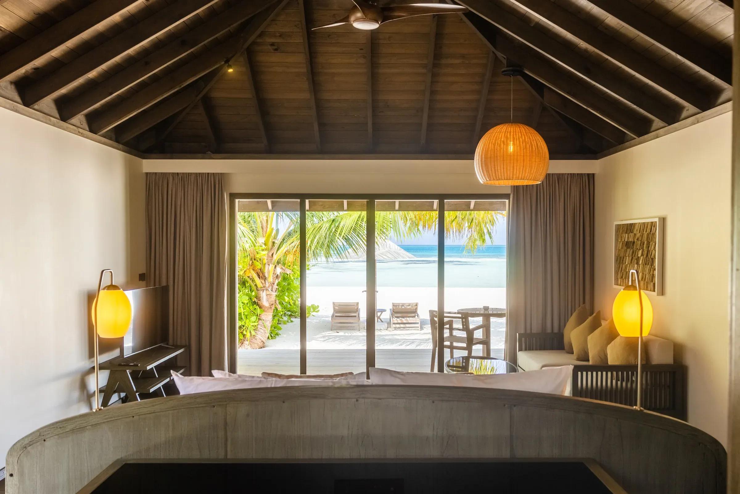Vista dalla Mabin Beach Villa su terrazza con sedie e accesso alla spiaggia del Jawakara Islands Maldives.