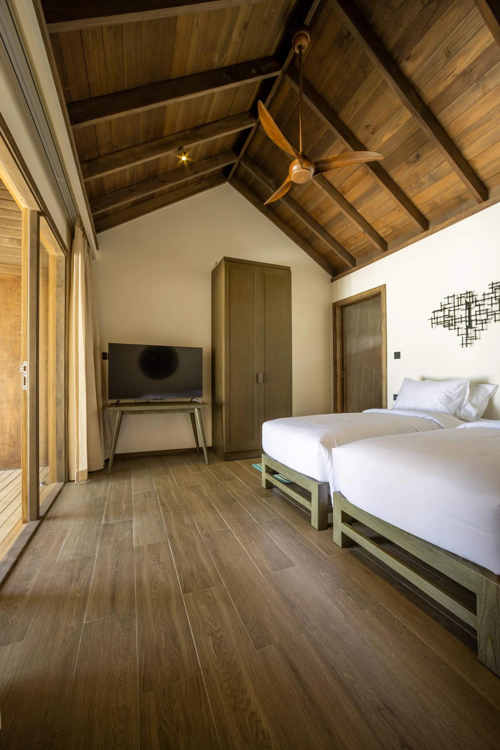 Interno della Mabin Three Bedroom Villa con letti singoli e TV, Jawakara Islands Maldives.