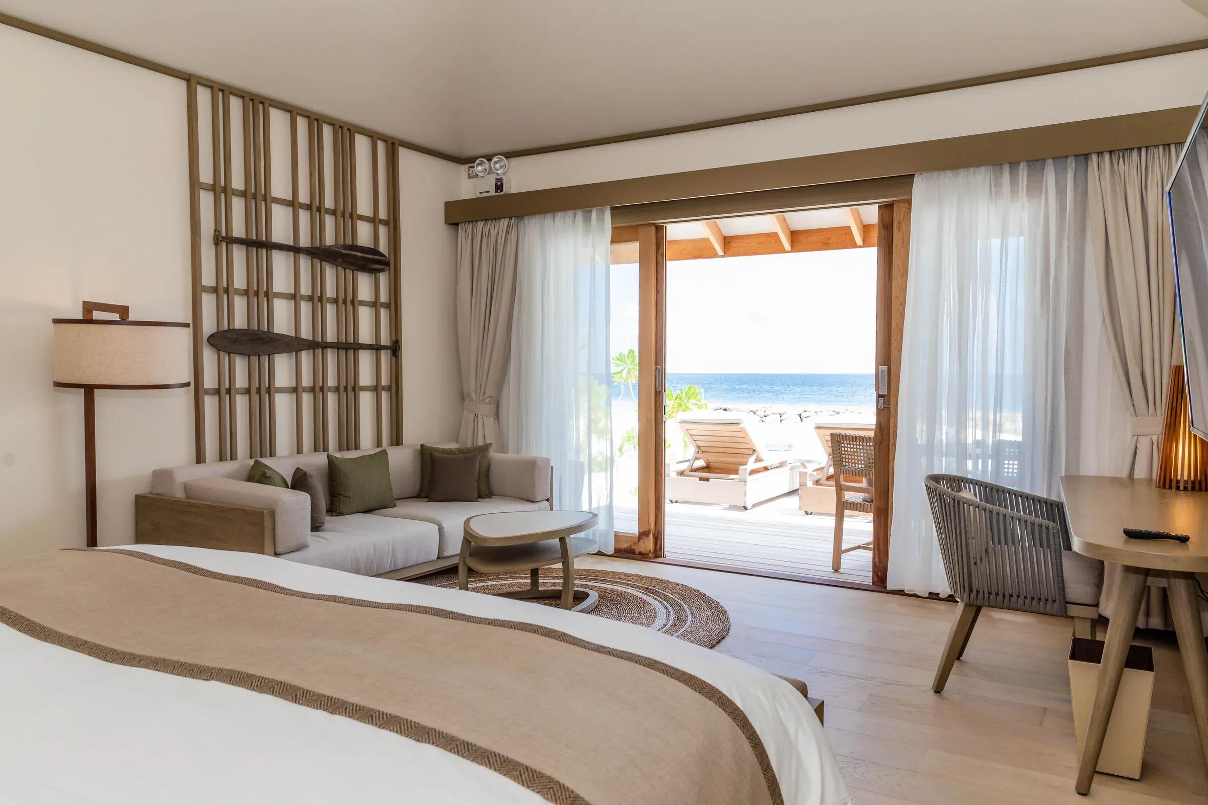 Interno della Beach Pool Villa con divano e vista mare al Kagi Maldives Spa Island.