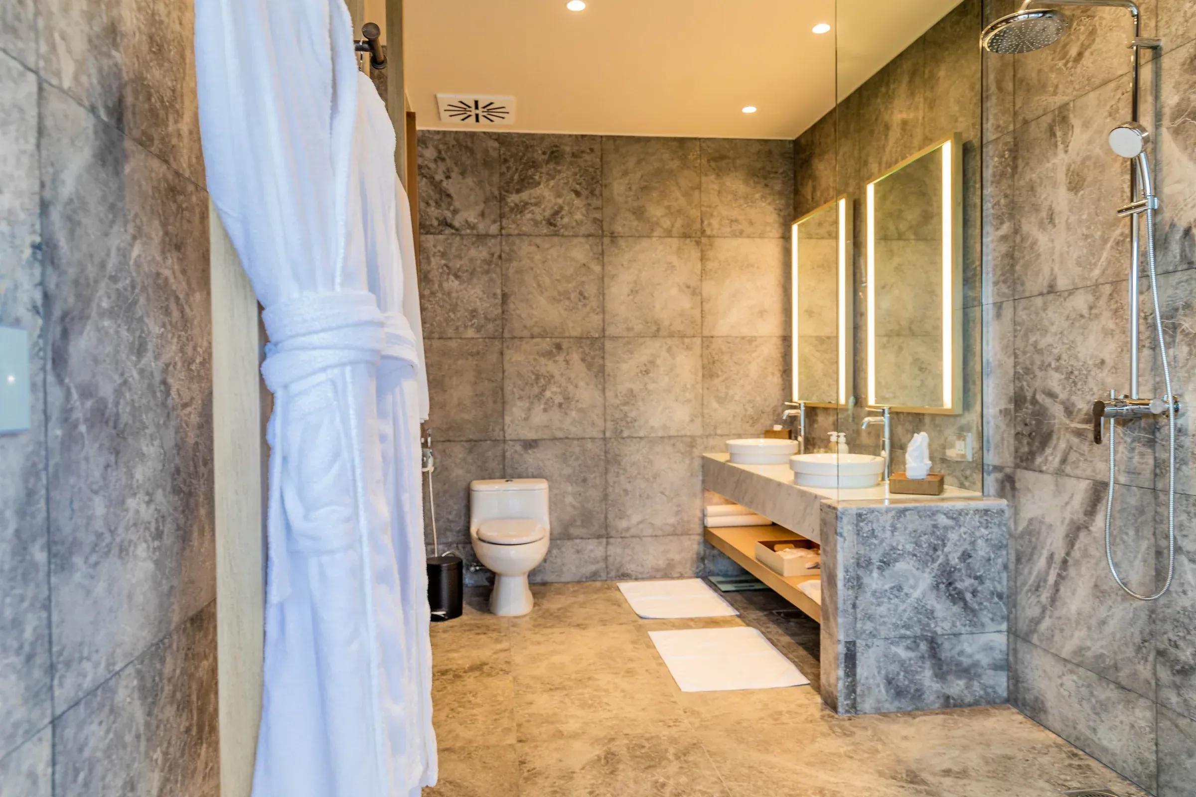 Bagno della Lagoon Pool Villa con due lavabi in marmo e doccia a pioggia al Kagi Maldives Spa Island.