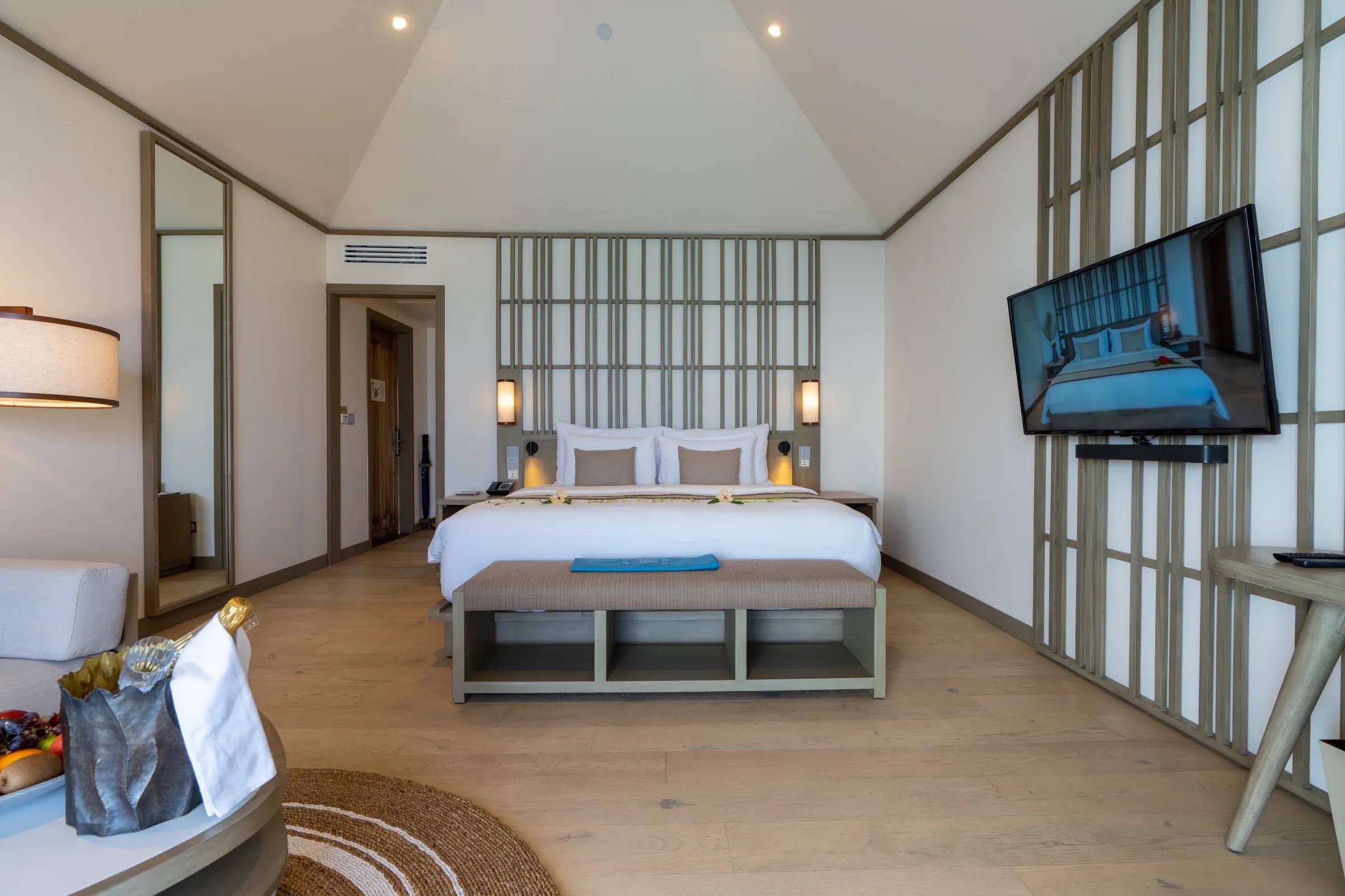 Camera Ocean Pool Villa con letto matrimoniale e TV al Kagi Maldives Spa Island.