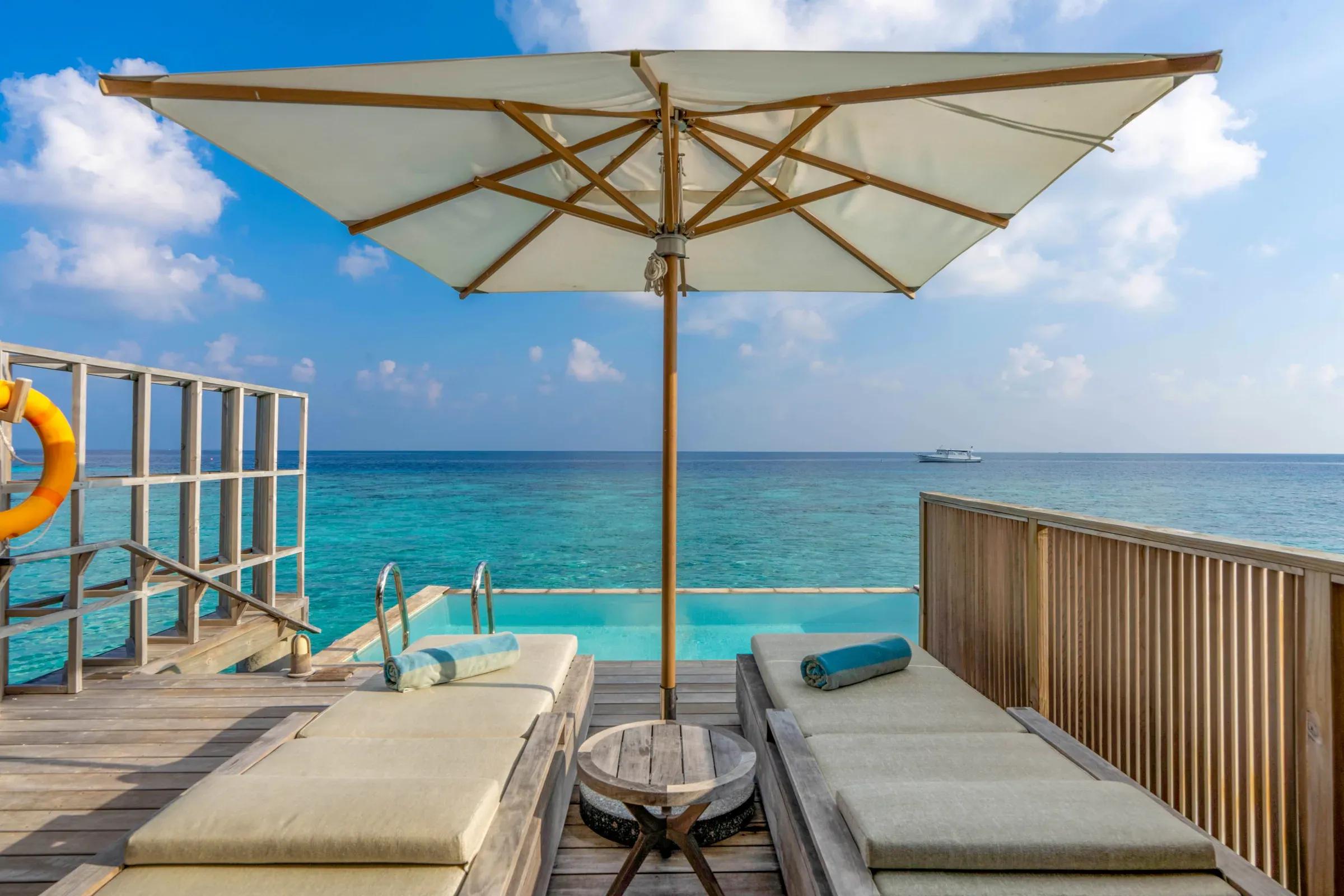Terrazza con ombrellone e lettini vista mare della Ocean Pool Villa al Kagi Maldives Spa Island.