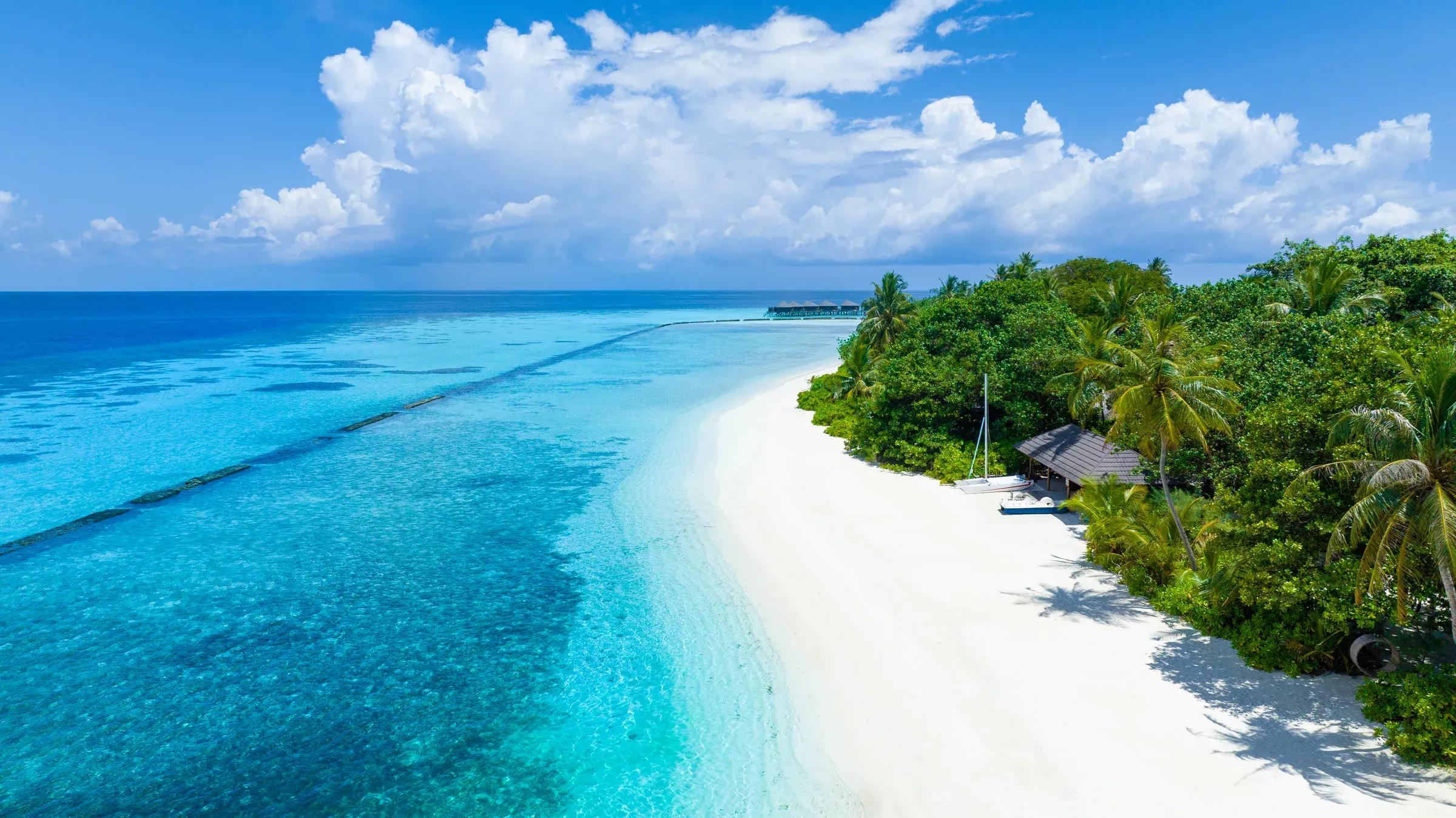 Spiaggia con sabbia bianca e palme presso il Komandoo Island Resort & Spa.