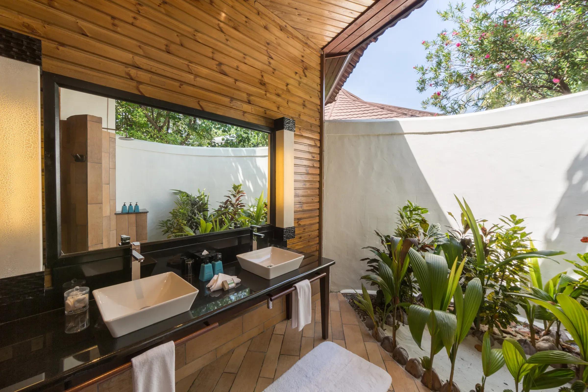 Bagno open-air della Beach Villa con doppio lavabo e piante al Komandoo Island Resort & Spa.