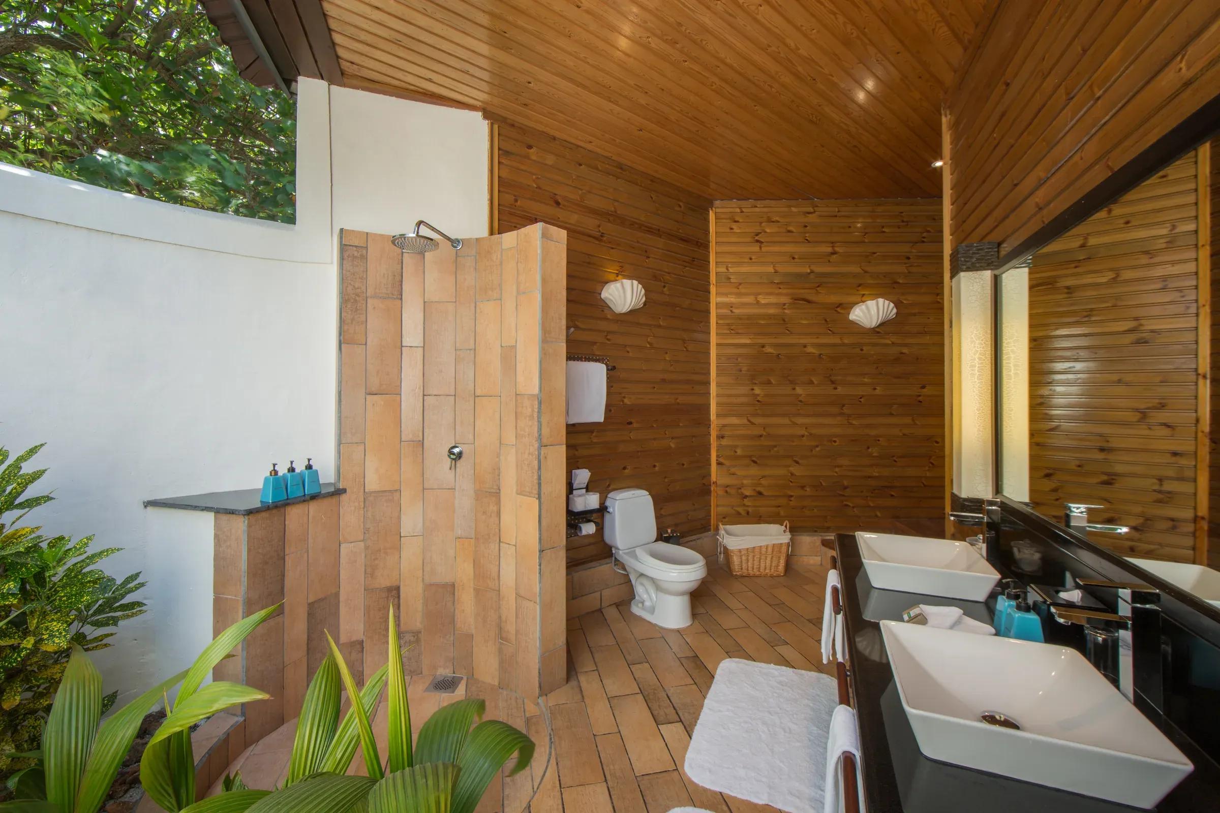 Bagno della Beach Villa con doccia aperta e doppio lavabo al Komandoo Island Resort & Spa.
