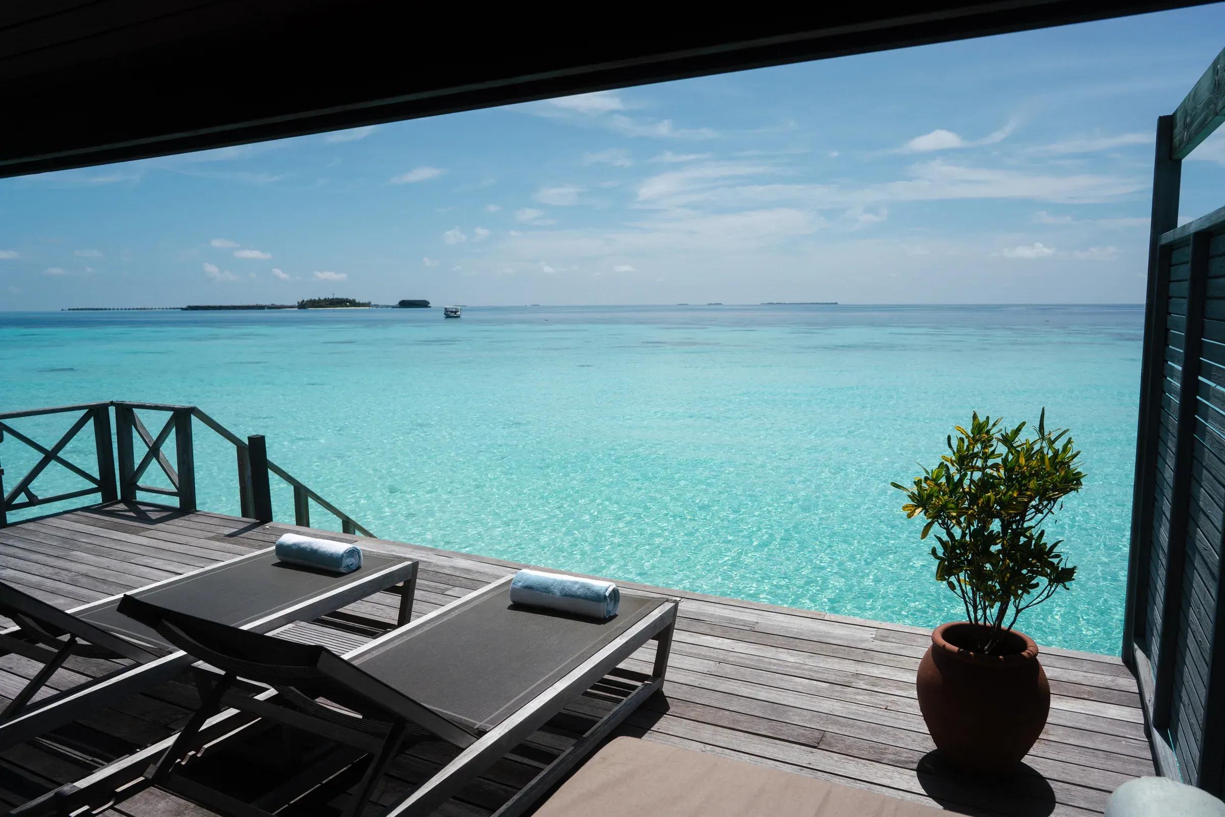 Terrazza della Jacuzzi Water Villa con lettini e vista sull'oceano al Komandoo Island Resort & Spa