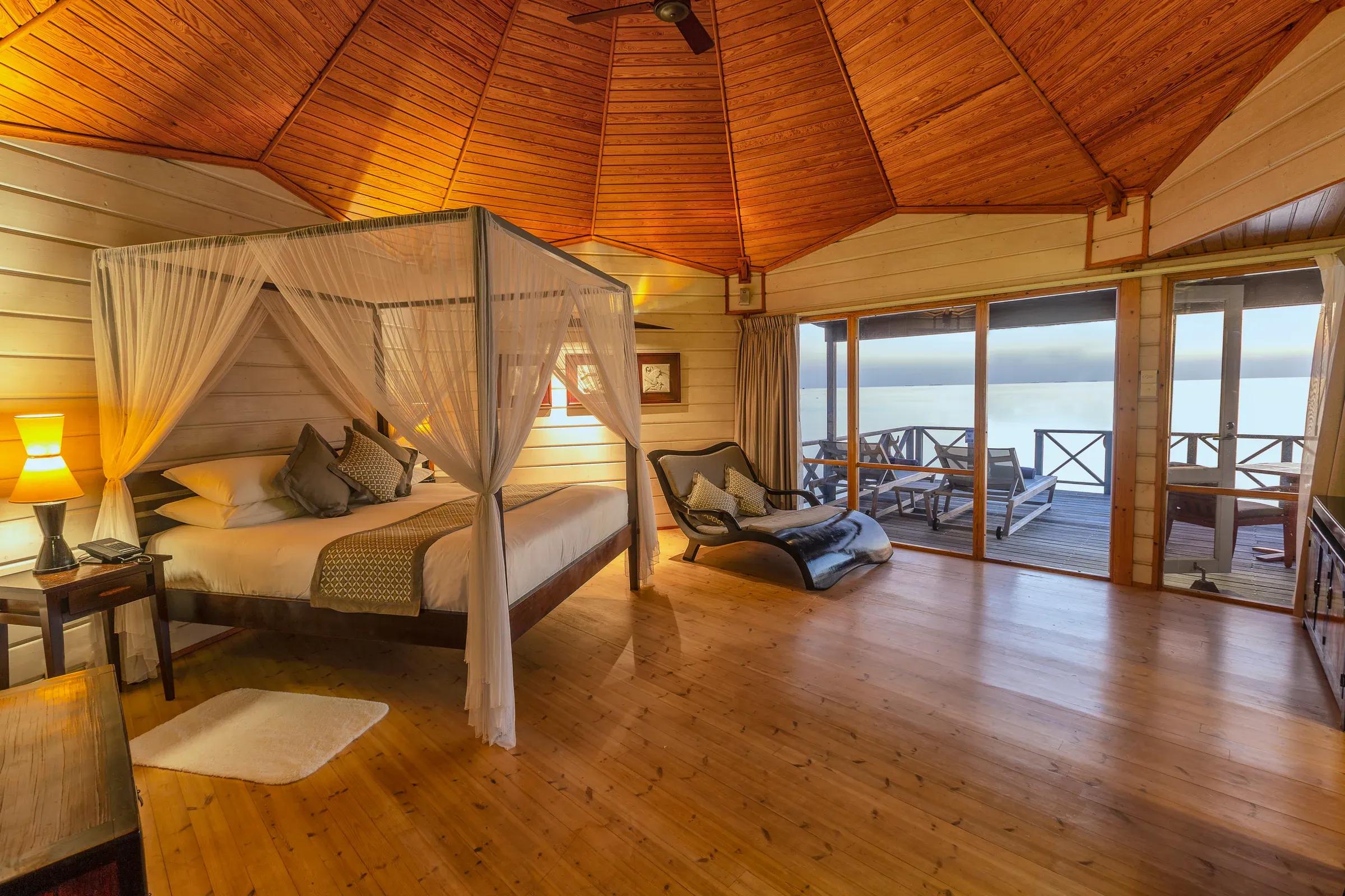 Camera Ocean Jacuzzi Water Villa con letto a baldacchino e terrazza con vista mare al Komandoo Island Resort & Spa.