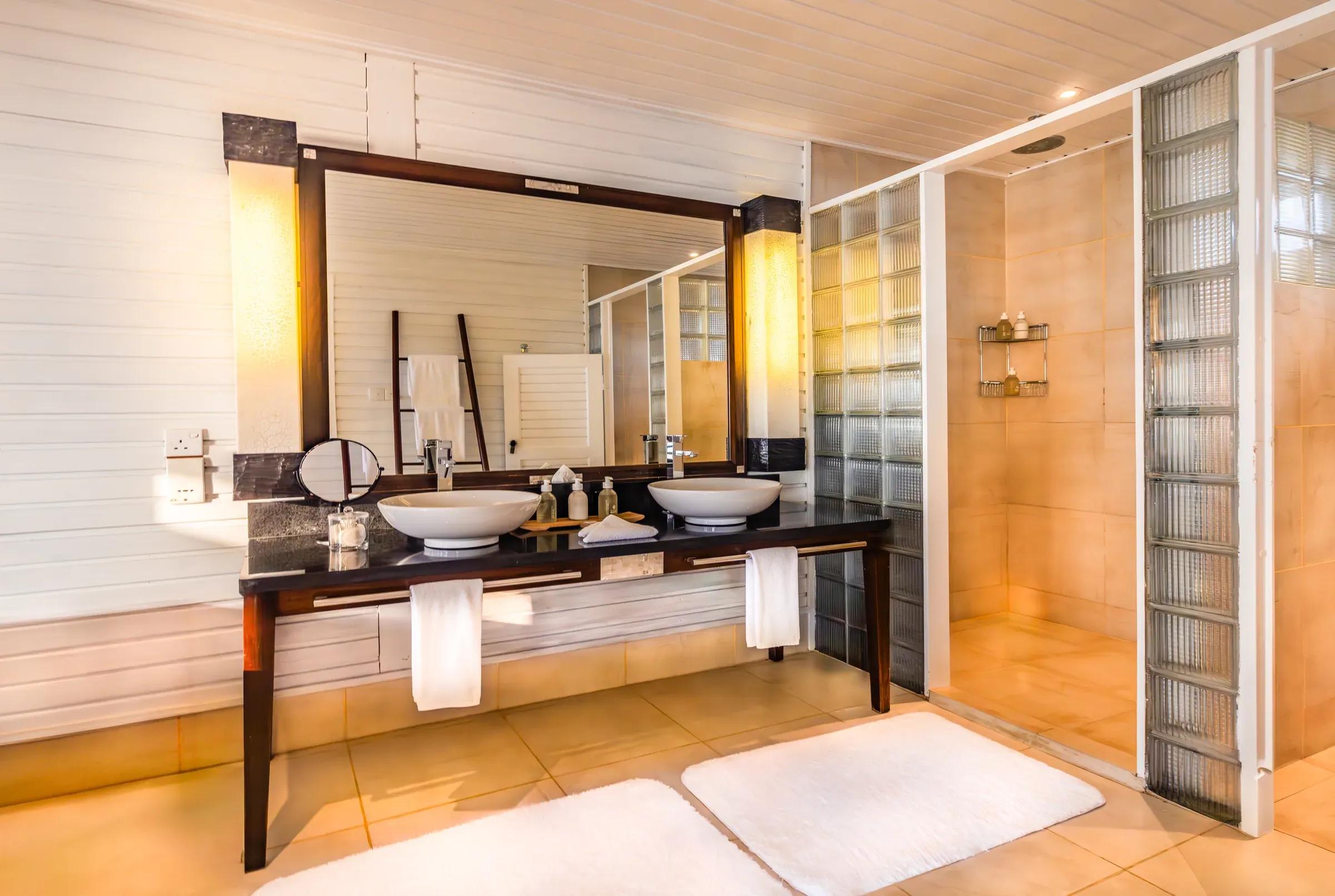 Bagno della Ocean Jacuzzi Water Villa con lavabo doppio e doccia presso Komandoo Island Resort & Spa.