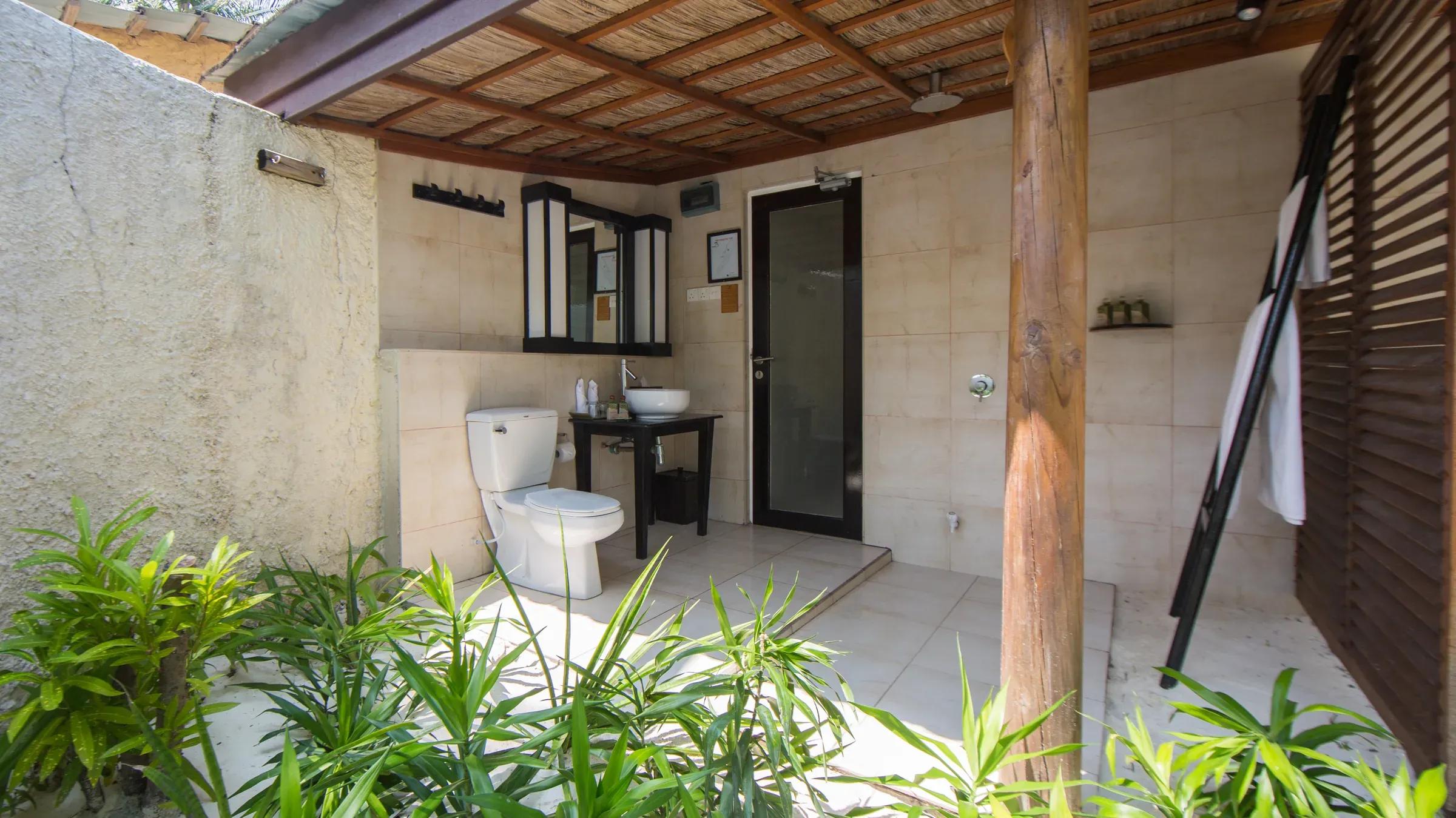 Bagno all'aperto della Beach Bungalow con lavabo e vegetazione al Kuredu Island Resort & Spa.