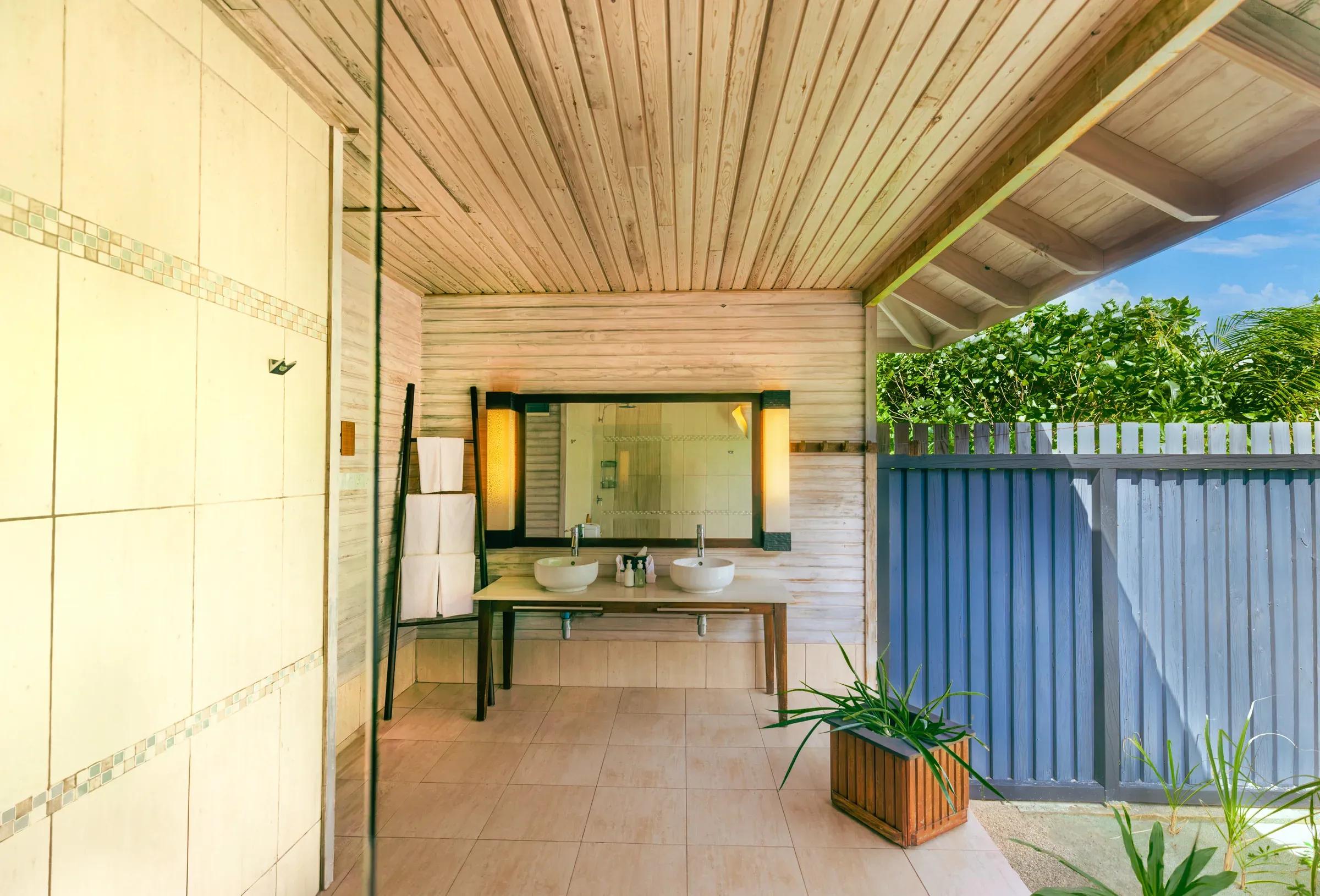 Bagno della Beach Villa con doppio lavabo e vista sul giardino al Kuredu Island Resort & Spa