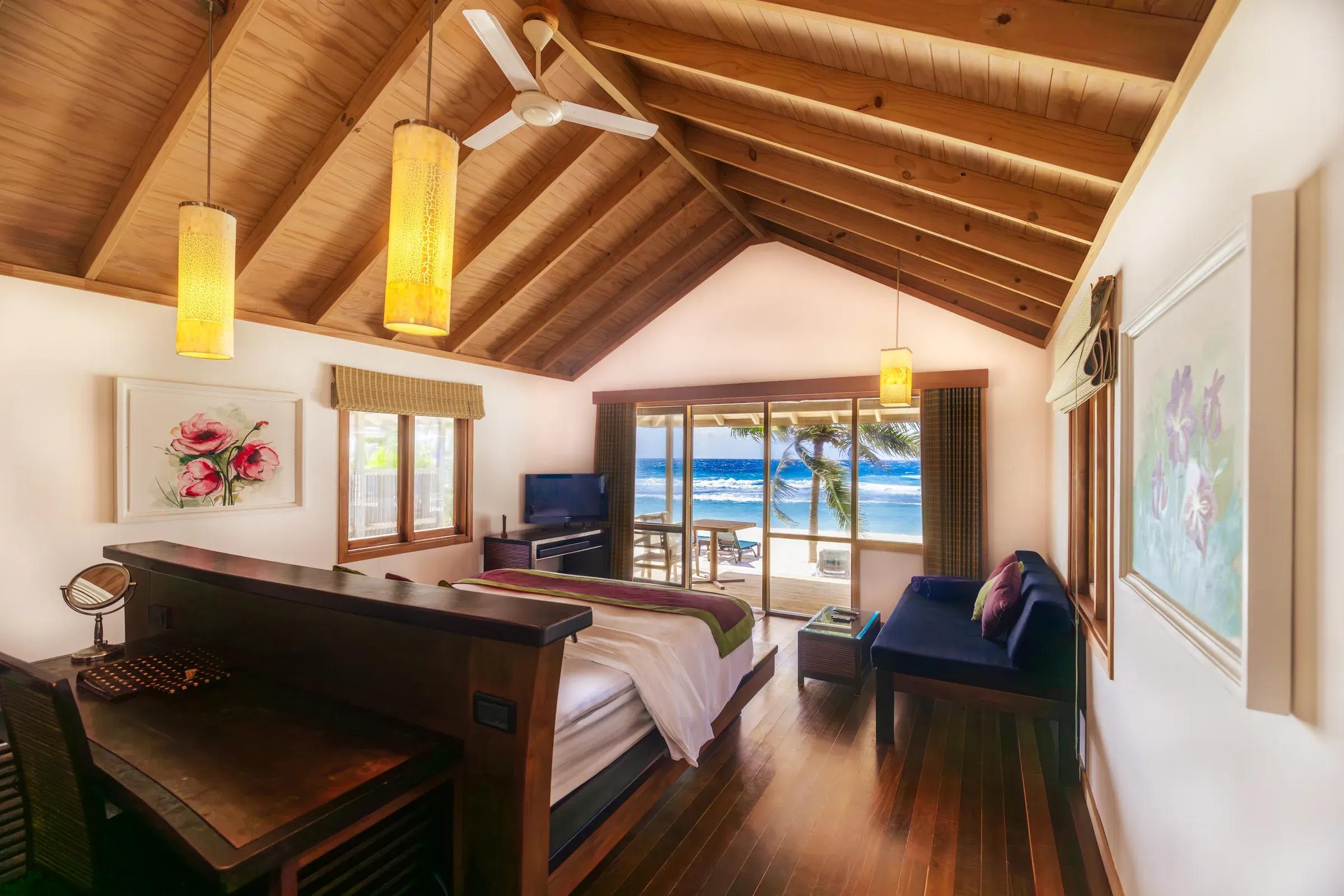 Interno della Beach Villa con letto e vista sul mare al Kuredu Island Resort & Spa