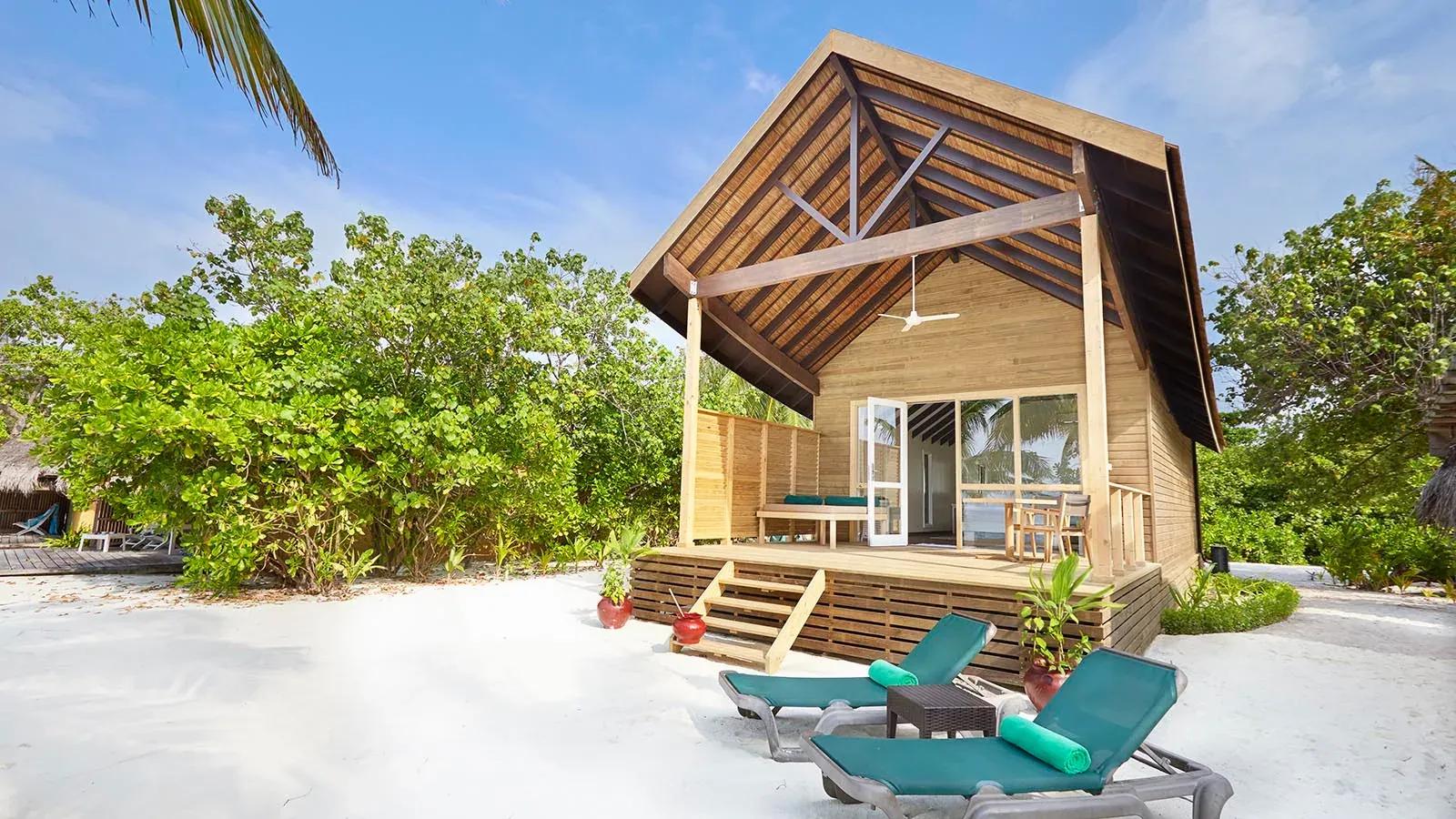 Terrazza della Deluxe Beach Villa con sedie a sdraio e accesso alla spiaggia del Kuredu Island Resort & Spa.