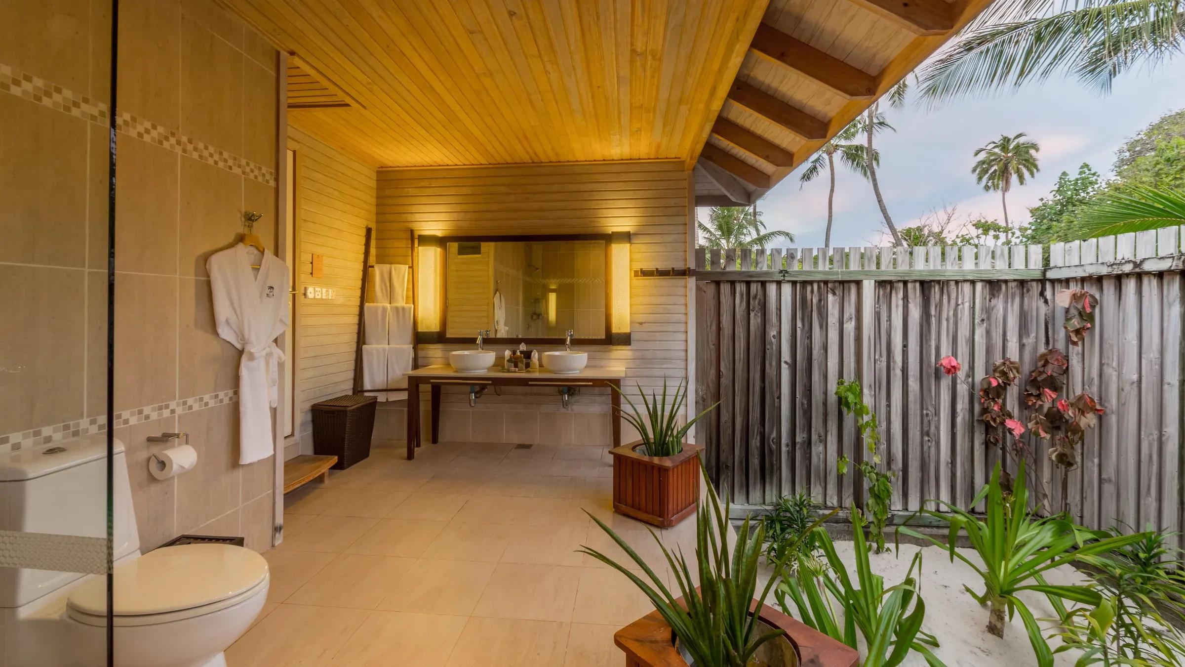 Bagno della O Beach Villa con doppio lavabo e giardino esterno al Kuredu Island Resort & Spa.