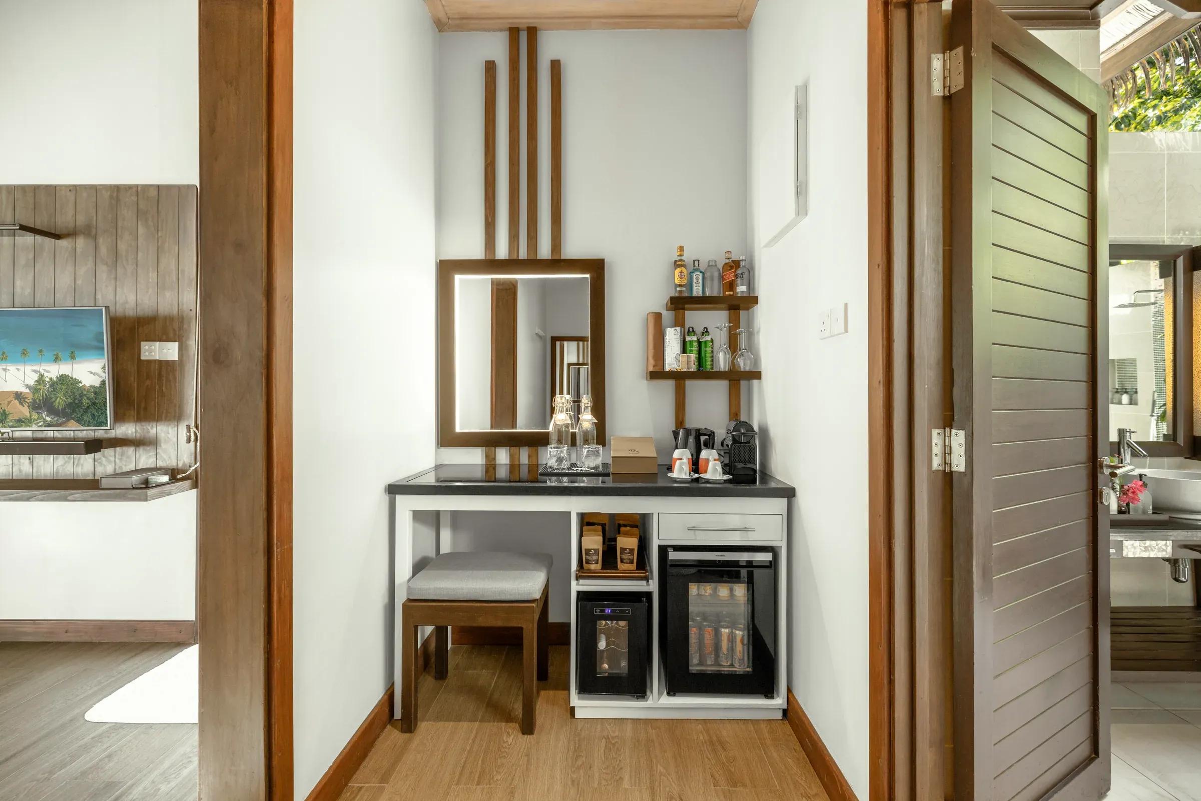 Angolo minibar con specchio e selezione di bevande nella Private Pool Villa Family Suite al Kuredu Island Resort & Spa.