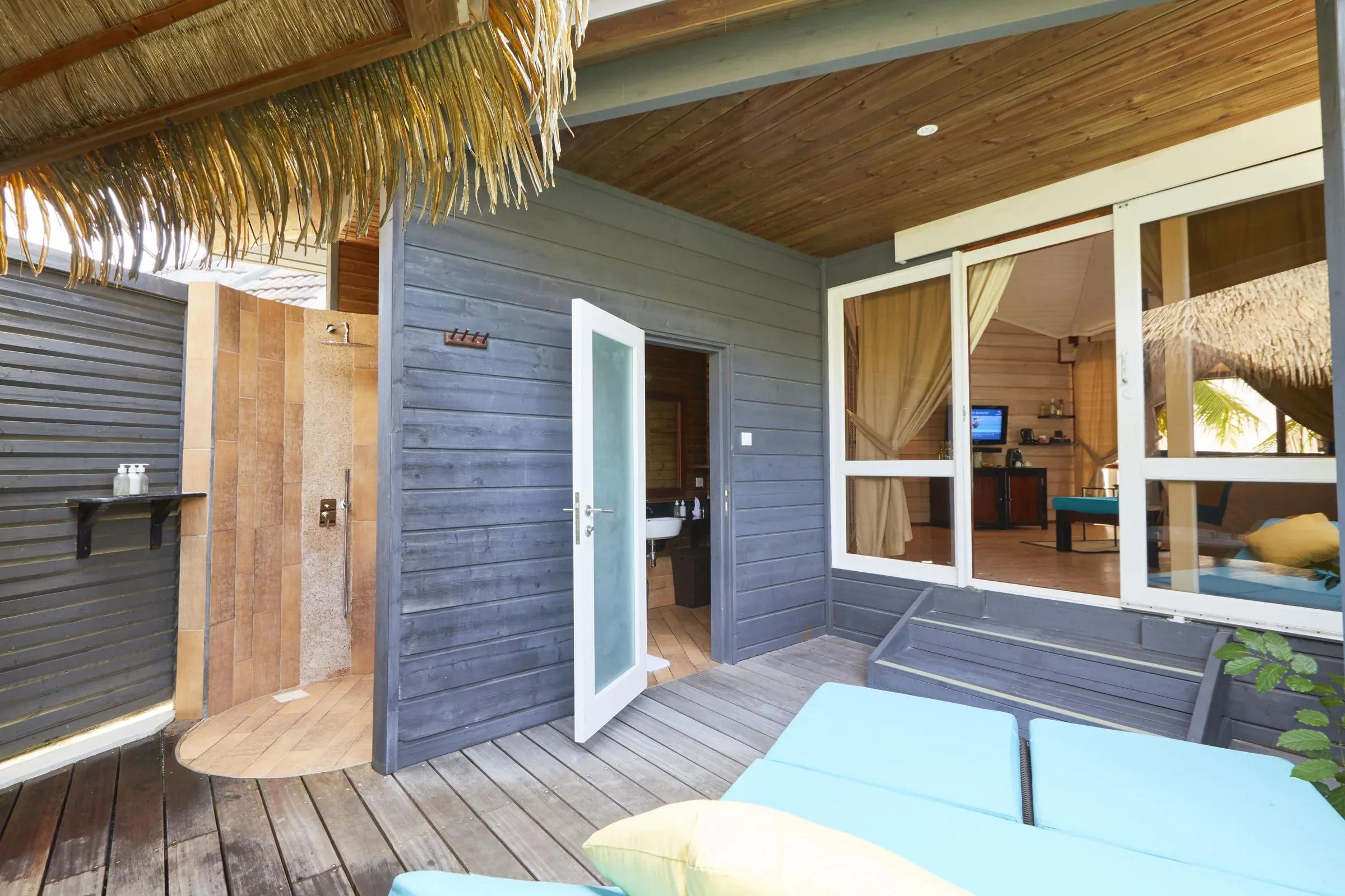 Terrazza della Sangu Jacuzzi Beach Villa con sedute imbottite e doccia esterna al Kuredu Island Resort & Spa