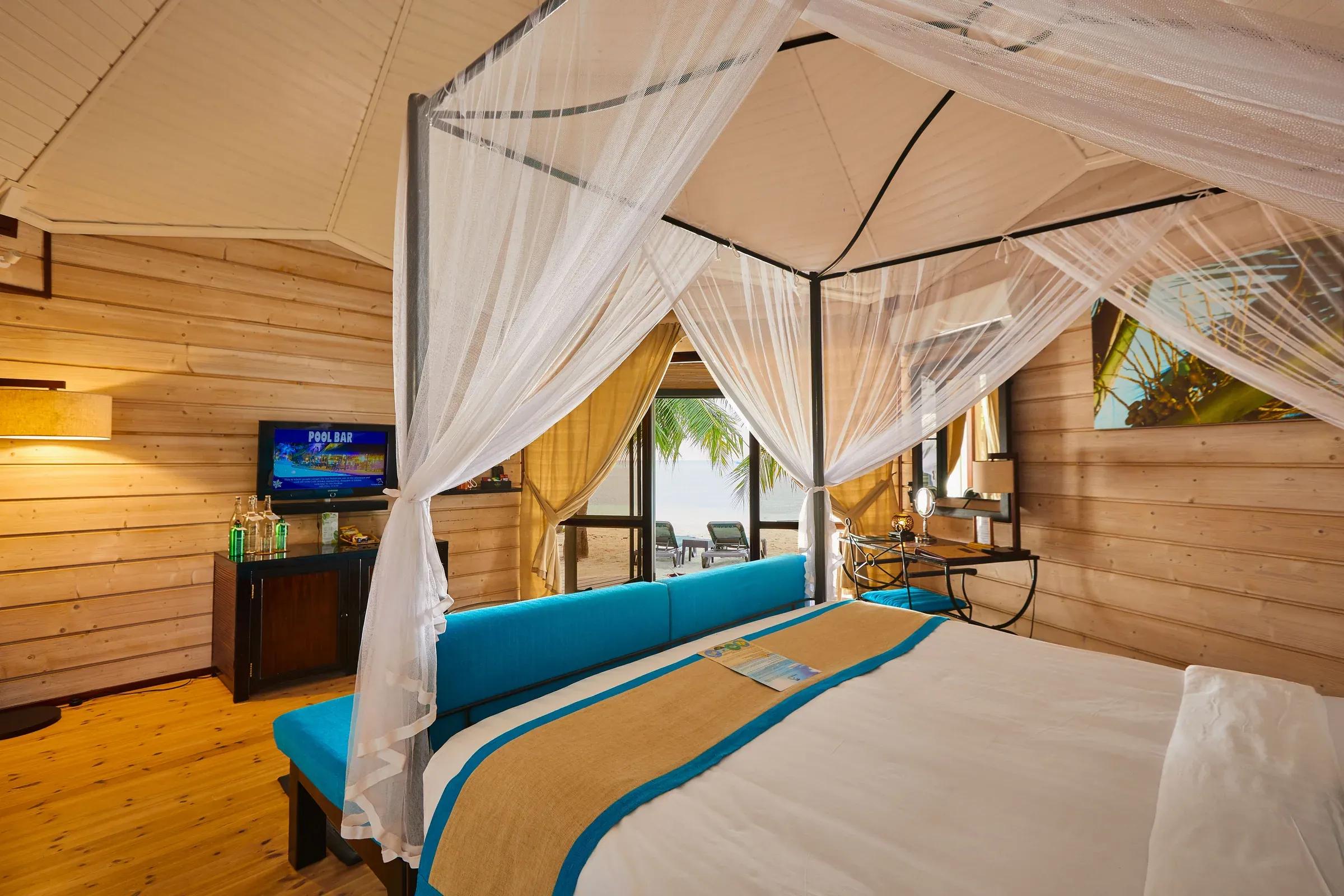Interno della Sangu Jacuzzi Beach Villa con letto a baldacchino e vista sul mare del Kuredu Island Resort & Spa.