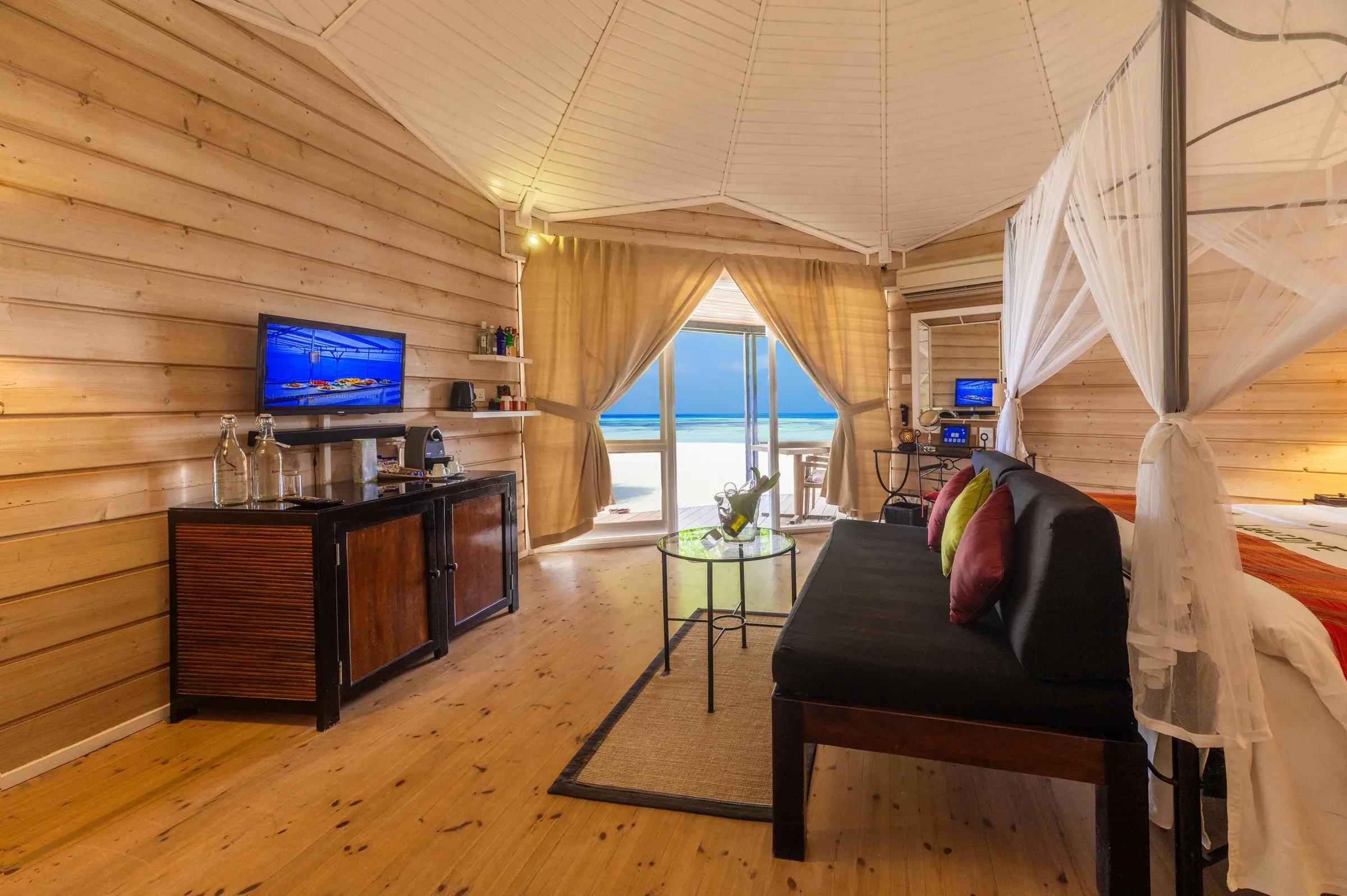 Interno della Sangu Premium Beach Villa con divano e vista mare al Kuredu Island Resort & Spa.