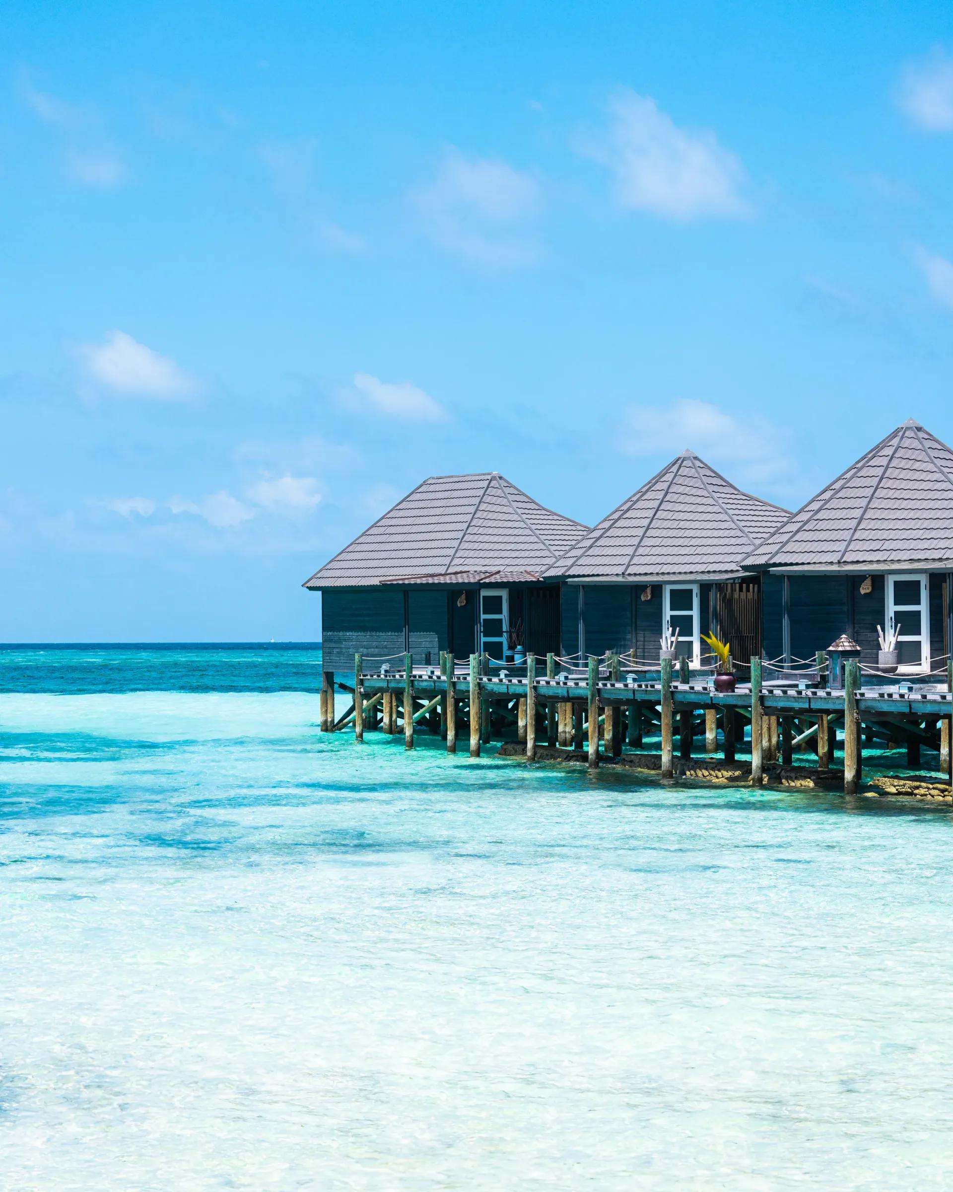 Ville sull'acqua della Sangu Water Villa con terrazza e vista sull'oceano cristallino al Kuredu Island Resort & Spa.