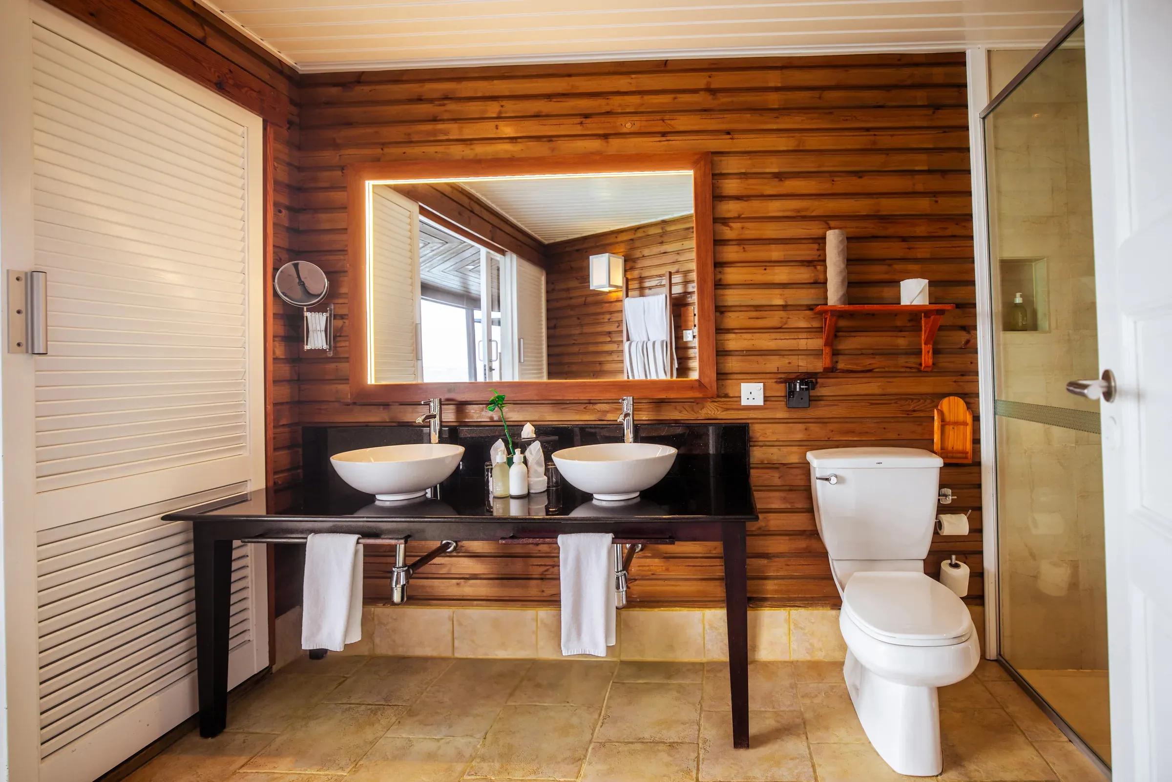 Bagno della Sangu Water Villa con doppio lavabo e pareti in legno al Kuredu Island Resort & Spa.