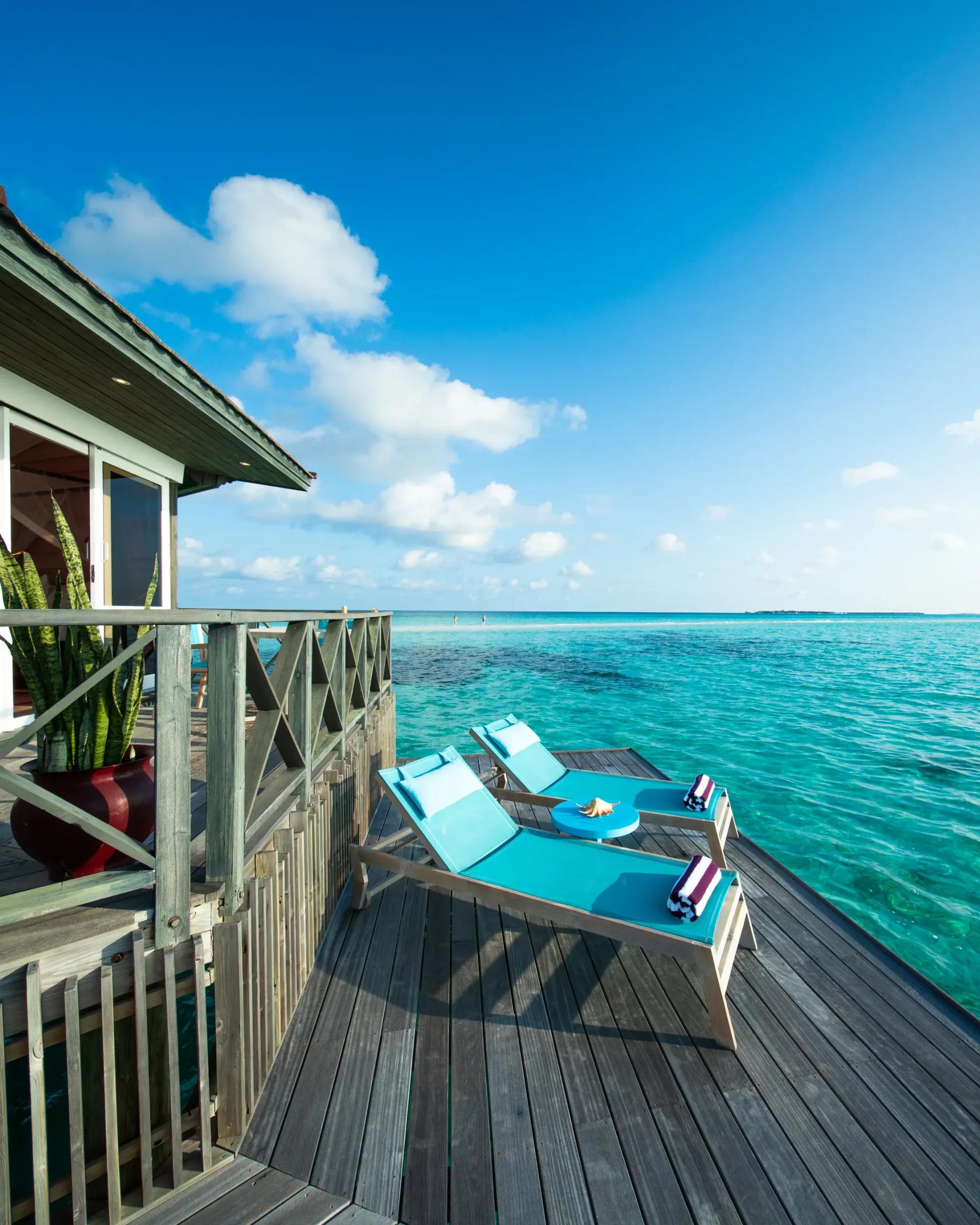 Terrazza della Sangu Water Villa Honeymoon Suite con lettini e vista sull'oceano al Kuredu Island Resort & Spa
