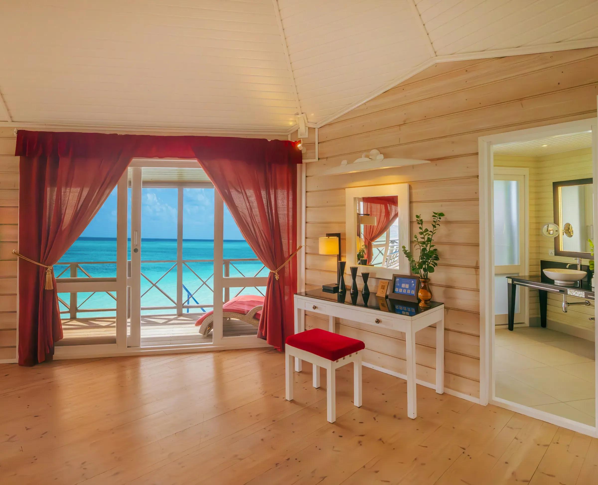 Interno della Sangu Water Villa Honeymoon Suite con balcone vista mare e bagno al Kuredu Island Resort & Spa.
