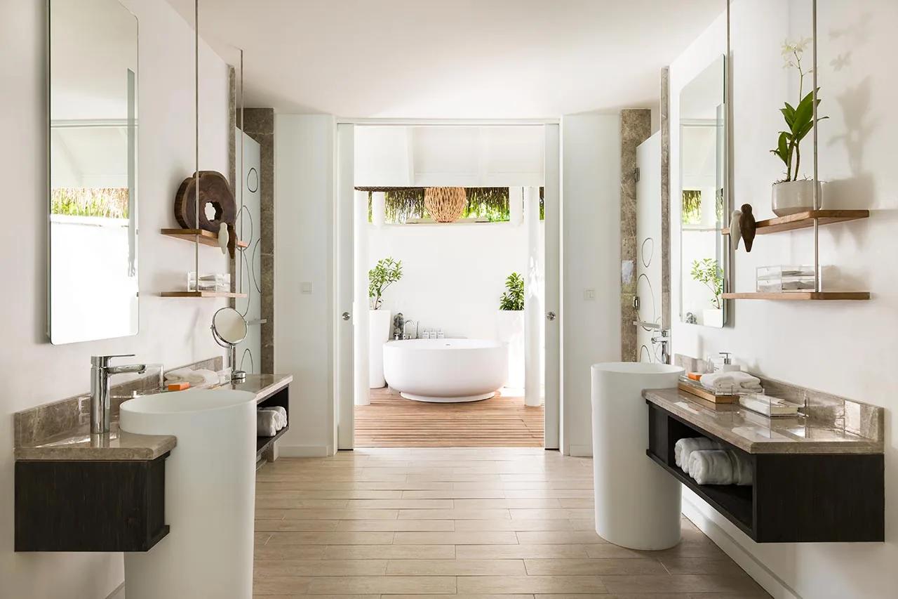 Bagno della Beach Villa con doppio lavandino e vasca all'aperto al LUX* South Ari Atoll.