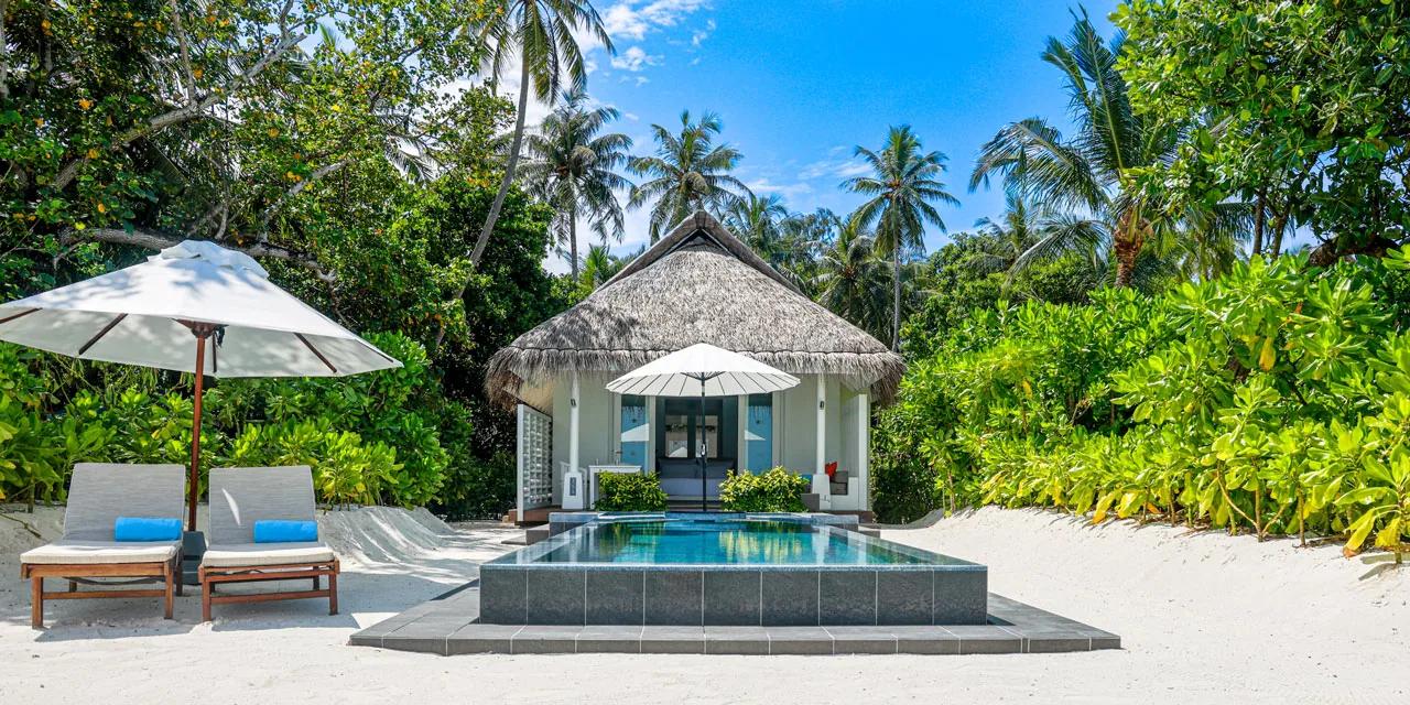 Beachfront Infinity Pool Villa con piscina privata e lettini sulla spiaggia del LUX* South Ari Atoll.