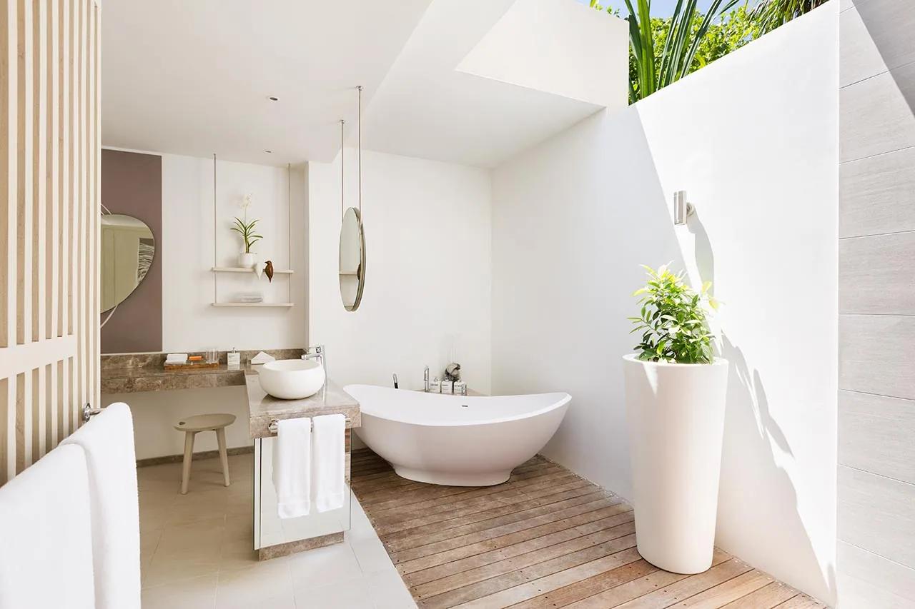 Bagno della Family Lagoon Pavilion con vasca freestanding e pianta decorativa al LUX* South Ari Atoll