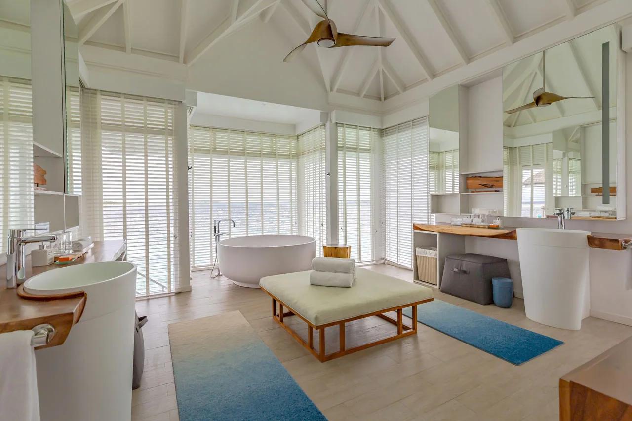 Bagno della Lux* Villa con vasca freestanding e ampie finestre al LUX* South Ari Atoll.